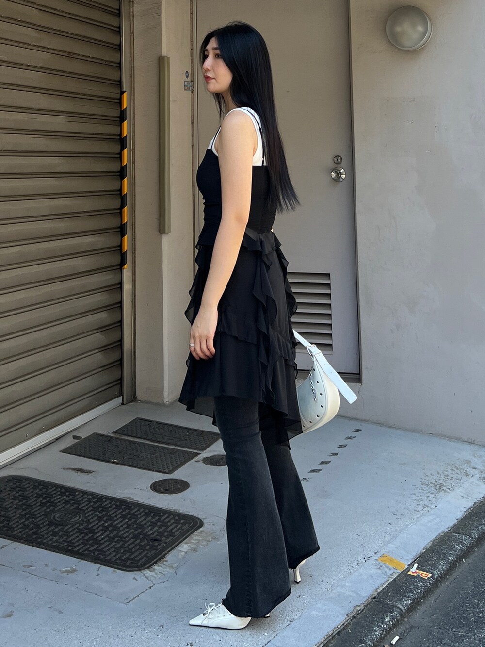 ブラック系のTシャツ/カットソー、ブラック系のスカート、ブラック系のデニムパンツを着用したレディースの春コーディネートの3枚目の写真