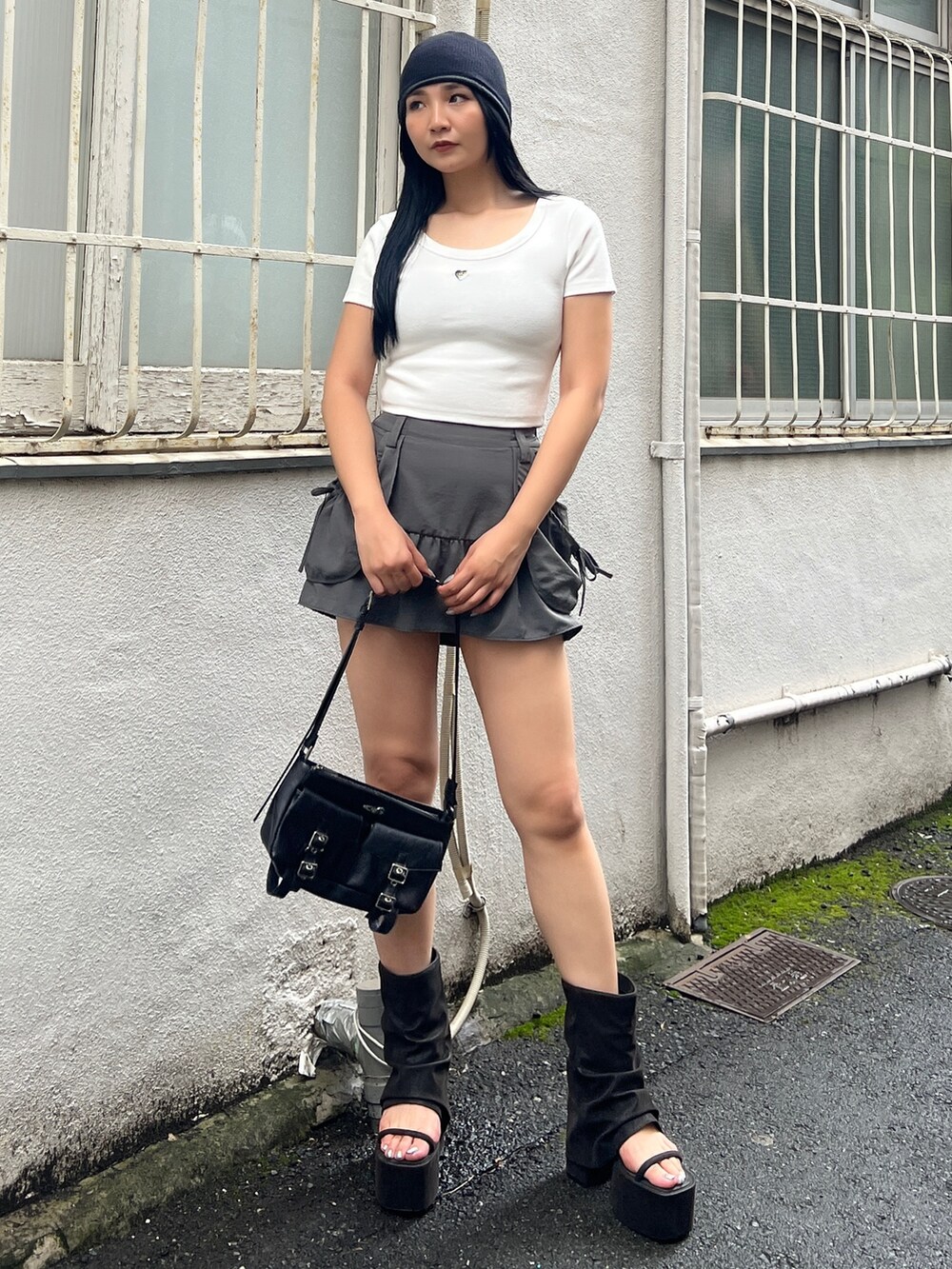 ホワイト系のTシャツ/カットソー、グレー系のスカート、ブラック系のサンダルを着用したレディースの夏コーディネートの3枚目の写真