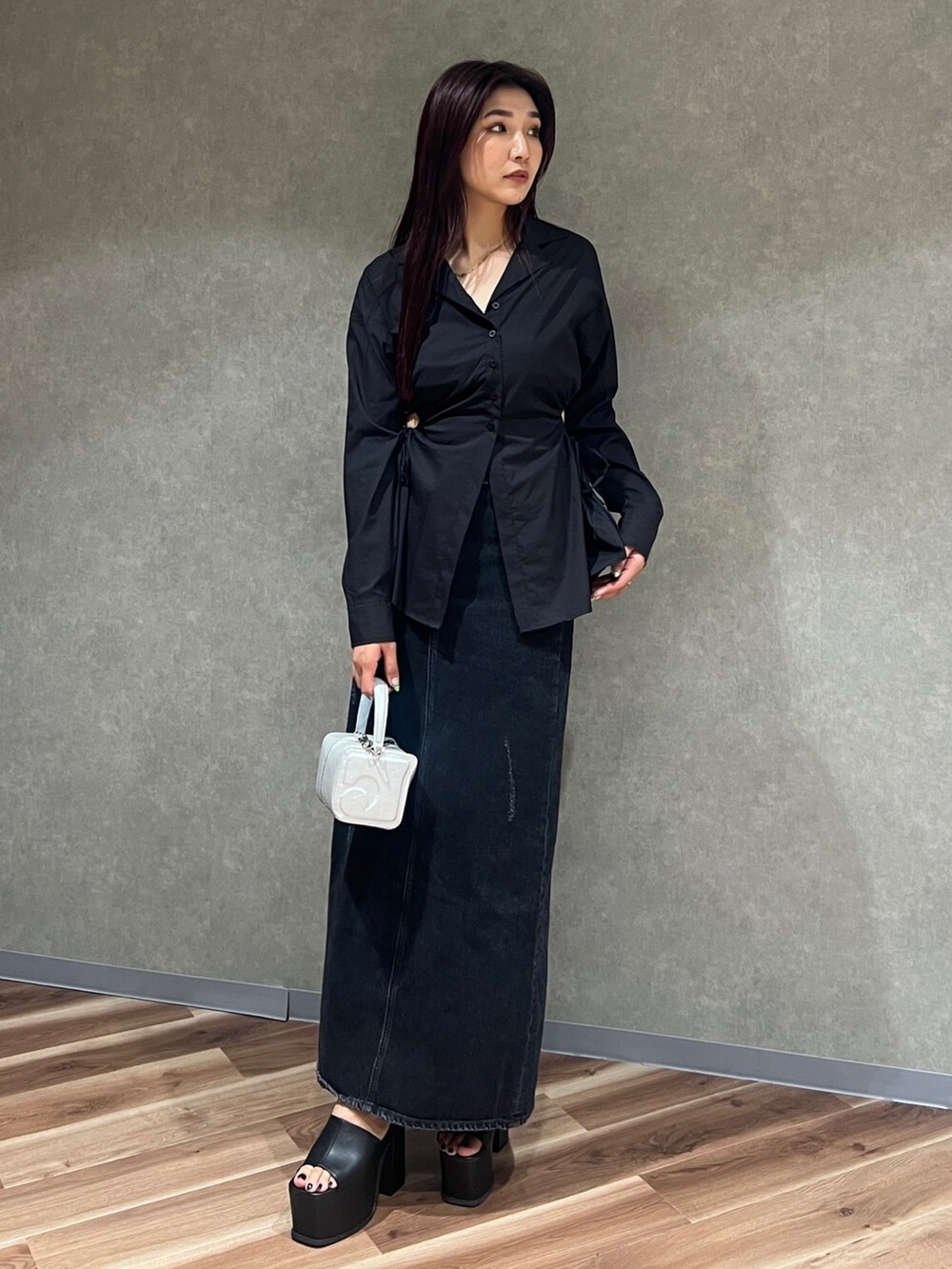 ブラック系のシャツ/ブラウス、ブラック系のスカート、グレー系のハンドバッグを着用したレディースの夏コーディネートの3枚目の写真