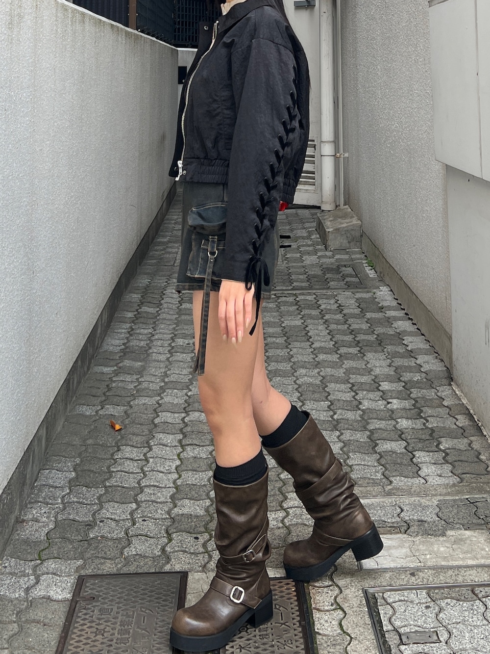 ブラック系のブルゾン、ベージュ系のニット/セーター、ブルー系のその他パンツを着用したレディースの冬コーディネートの3枚目の写真