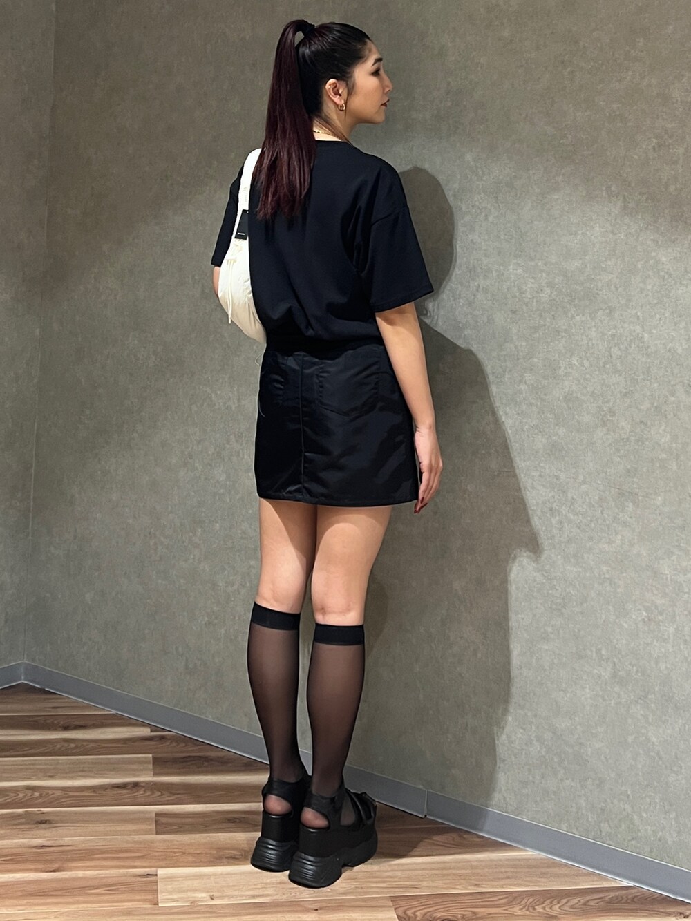 ブラック系のTシャツ/カットソー、ブラック系のスカート、ブラック系のサンダルを着用したレディースの春コーディネートの3枚目の写真
