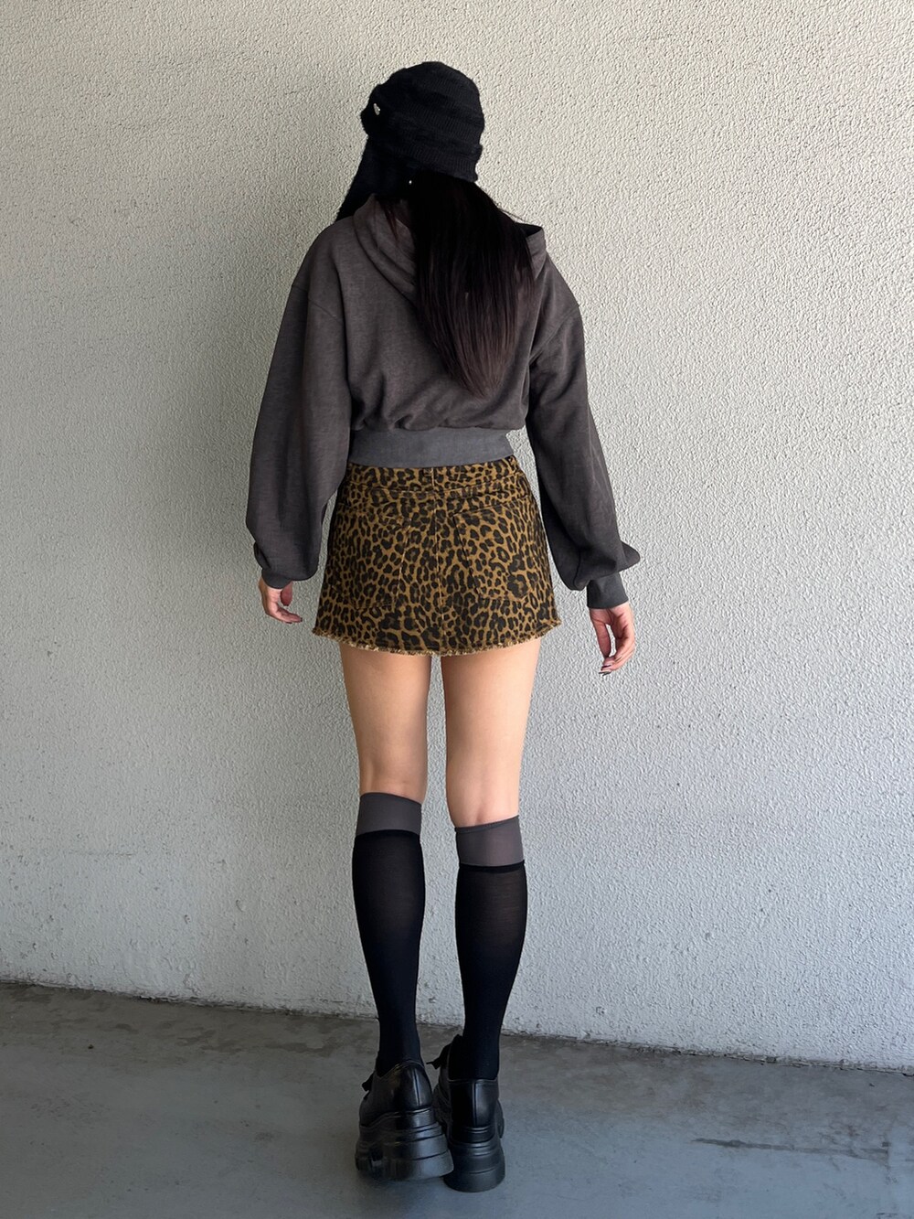 ブラック系のパーカー、ベージュ系のスカート、ブラック系のローファーを着用したレディースの夏コーディネートの3枚目の写真