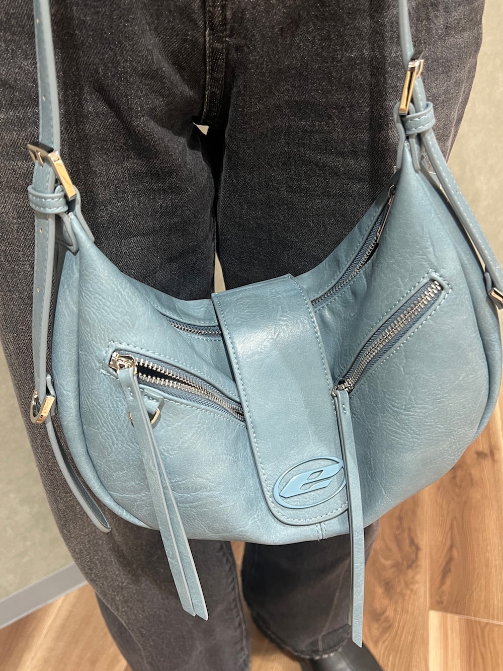 ブラック系のブルゾン、ブルー系のニット/セーター、ブラック系のデニムパンツを着用したレディースの冬コーディネートの7枚目の写真