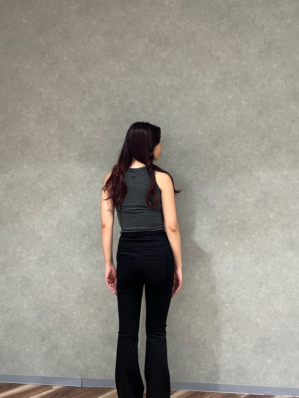 ブラック系のタンクトップ、ブラック系のデニムパンツ、ブラック系のサンダルを着用したレディースの夏コーディネートの3枚目の写真