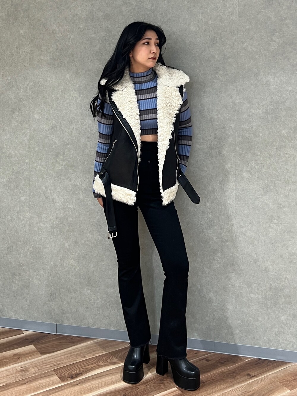 ブラック系のデニムパンツ、ブラック系のムートンコート、その他のニット/セーターを着用したレディースの秋コーディネートの3枚目の写真