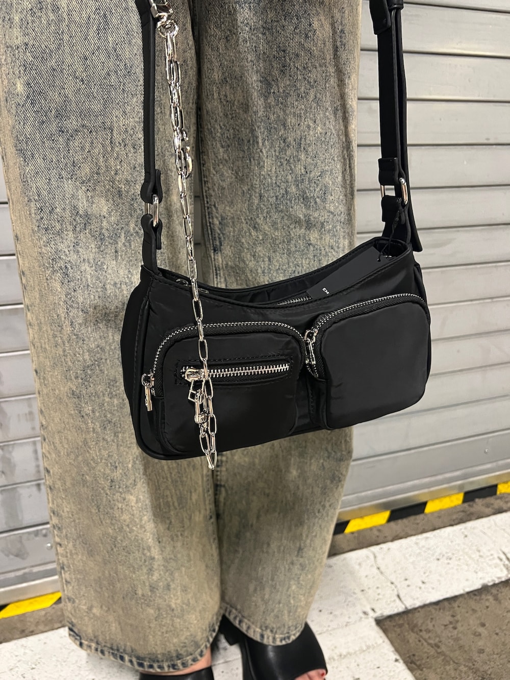 ベージュ系のデニムパンツ、ブラック系のハンドバッグ、ブラック系のサンダルを着用したレディースの夏コーディネートの5枚目の写真