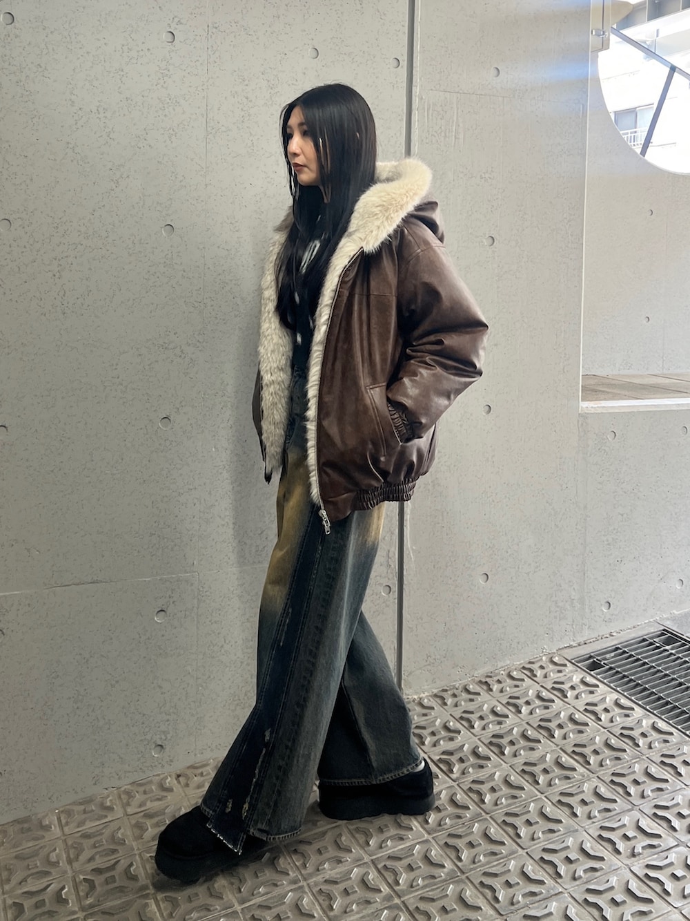 ブラック系のニット/セーター、ブルー系のデニムパンツ、ブラック系のスリッポンを着用したレディースの夏コーディネートの2枚目の写真