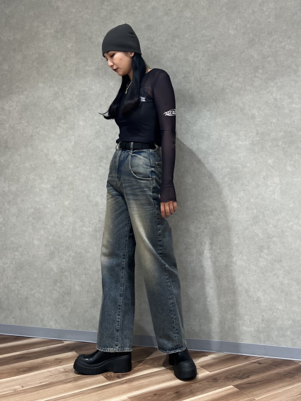 ブラック系のTシャツ/カットソー、ブルー系のデニムパンツ、ブラック系のブーツを着用したレディースの秋コーディネートの2枚目の写真