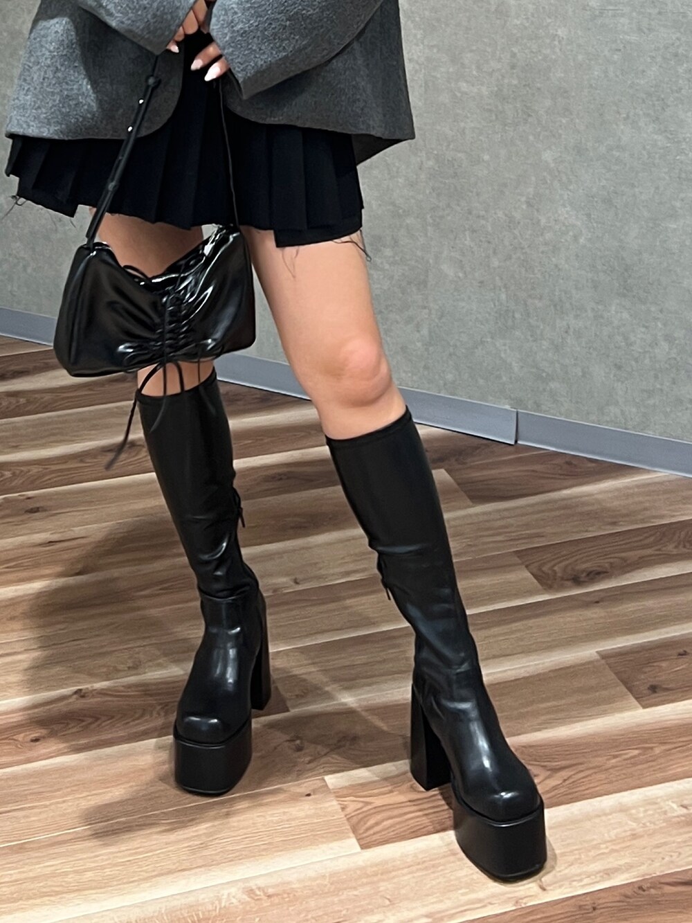 ブラック系のニット/セーター、グレー系のテーラードジャケット、ブラック系のスカートを着用したレディースの秋コーディネートの7枚目の写真