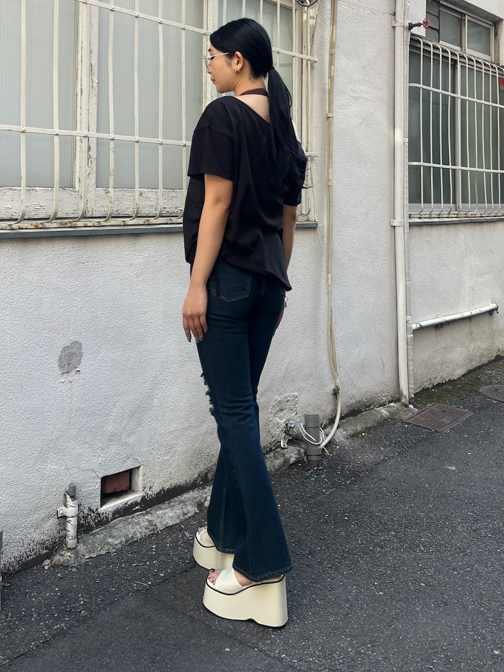 ブラック系のTシャツ/カットソー、ブラウン系のタンクトップ、ブルー系のデニムパンツを着用したレディースの春コーディネートの3枚目の写真