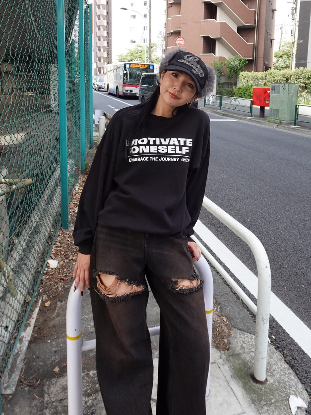 ブラック系のスウェット、ブラック系のデニムパンツ、ブラック系のハンドバッグを着用したレディースの夏コーディネートの3枚目の写真