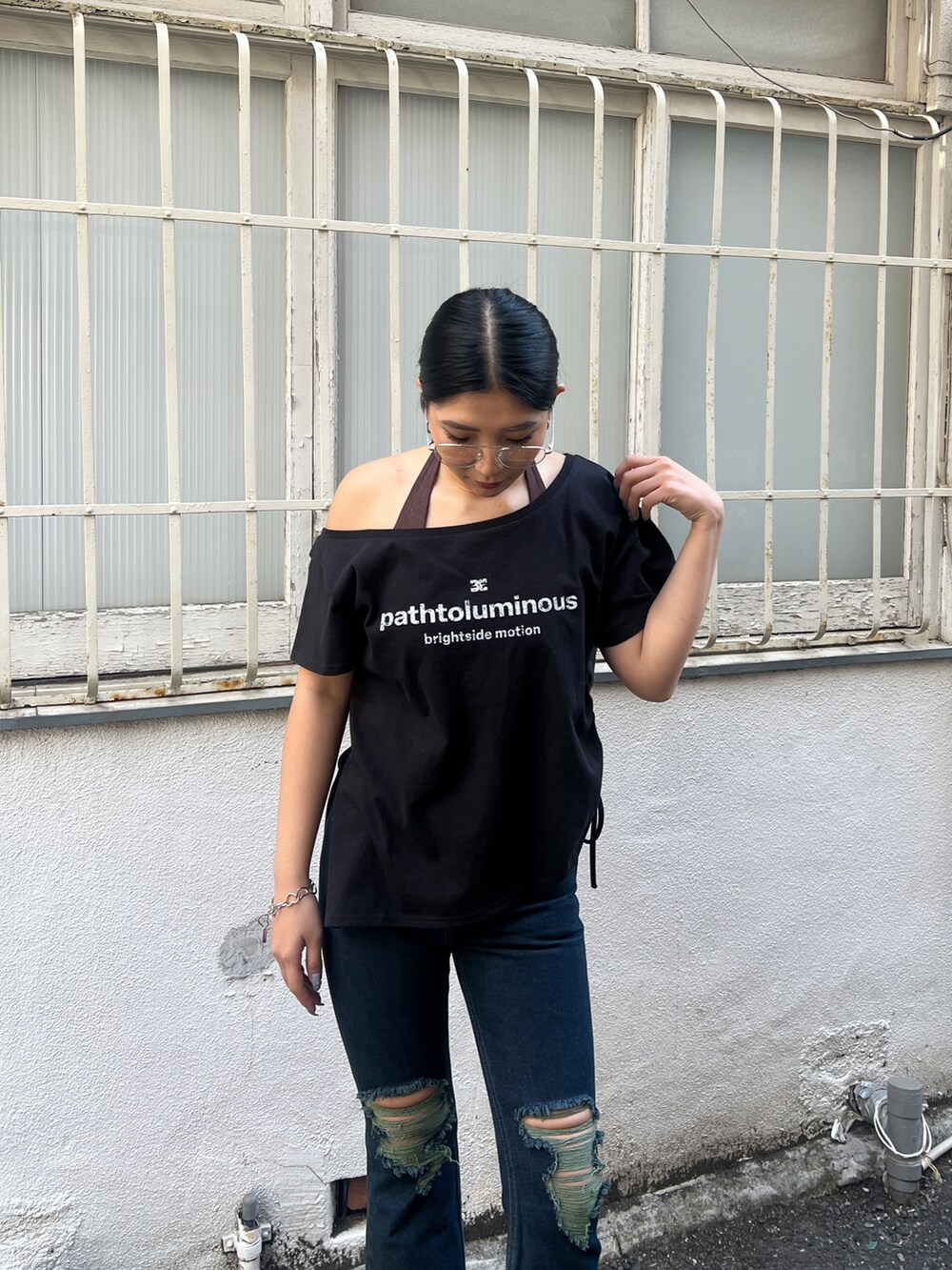 ブラック系のTシャツ/カットソー、ブラウン系のタンクトップ、ブルー系のデニムパンツを着用したレディースの春コーディネートの4枚目の写真