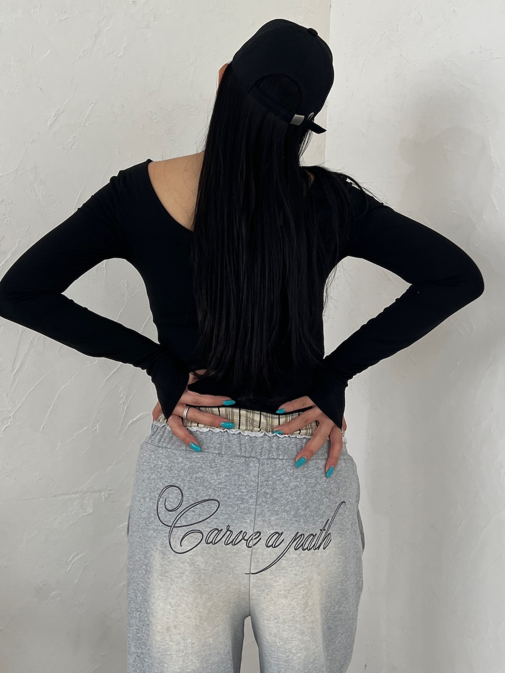 ブラック系のスウェットパンツ、ブラック系のスニーカー、ブラック系のキャップを着用したレディースの春コーディネートの4枚目の写真