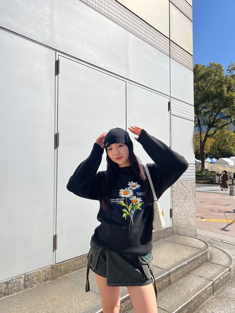 ブラック系のニット/セーター、ブルー系のその他パンツ、ブラック系のスニーカーを着用したレディースの春コーディネートの3枚目の写真