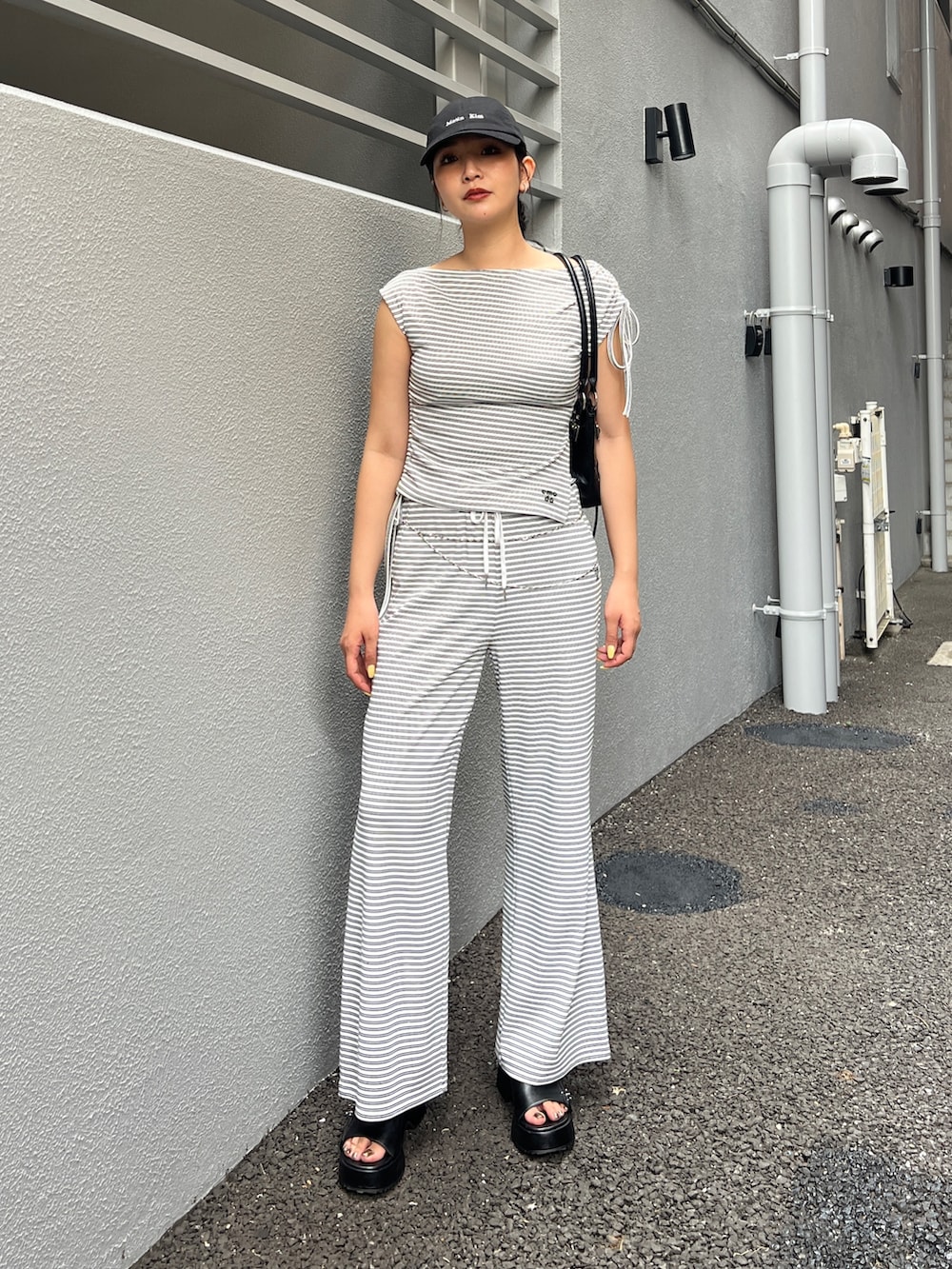 ホワイト系のTシャツ/カットソー、ホワイト系のその他パンツ、ブラック系のショルダーバッグを着用したレディースの春コーディネートの3枚目の写真