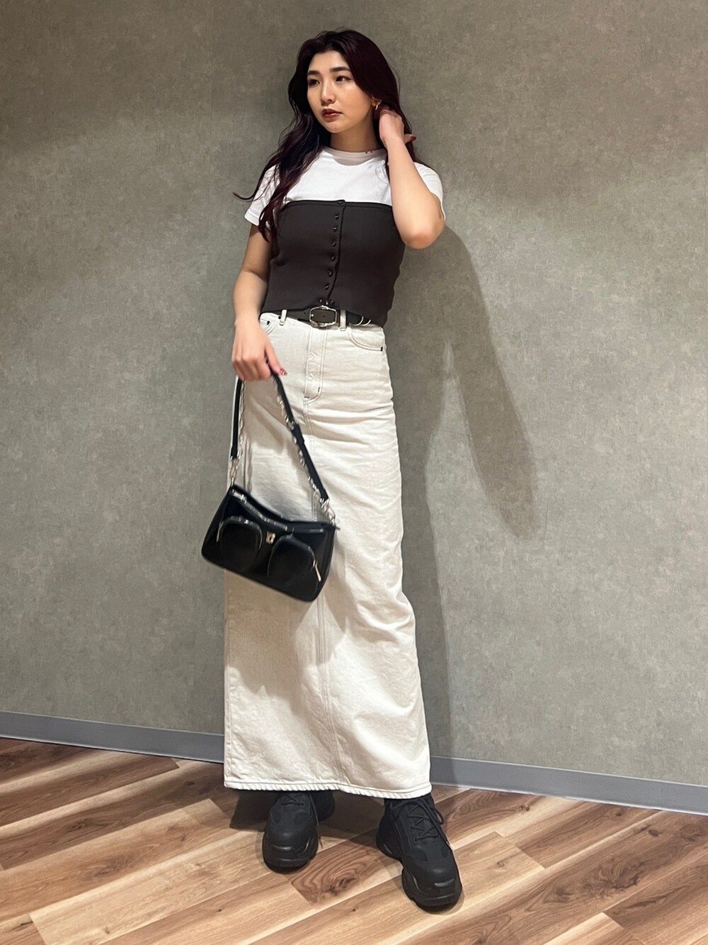 ブラウン系のチューブトップ、ホワイト系のTシャツ/カットソー、ブラック系のショルダーバッグを着用したレディースの春コーディネートの2枚目の写真