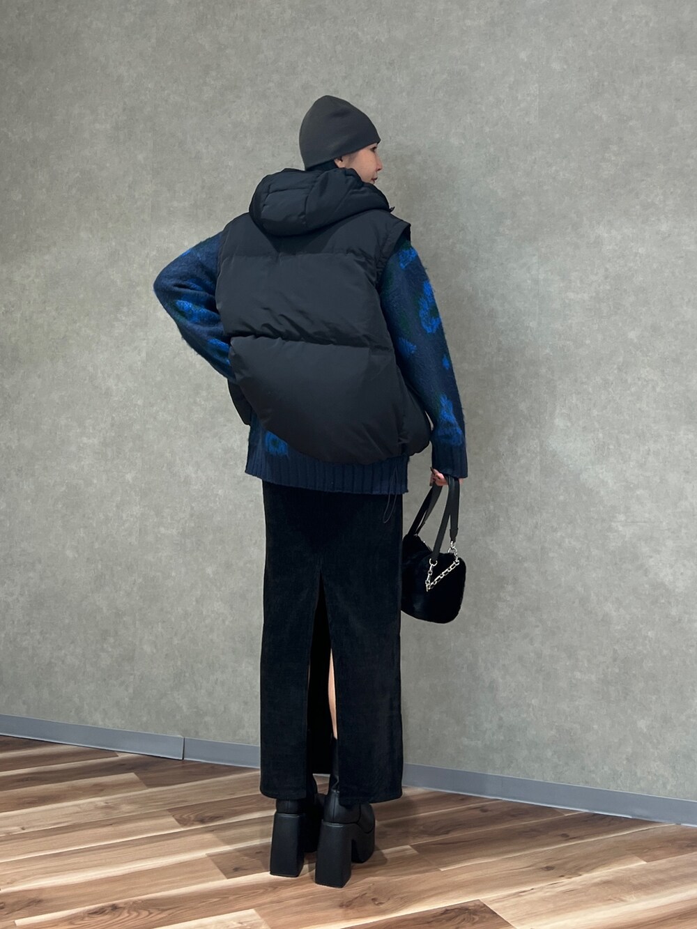 ブルー系のニット/セーター、ブラック系のブルゾン、ブラック系のスカートを着用したレディースの秋コーディネートの4枚目の写真