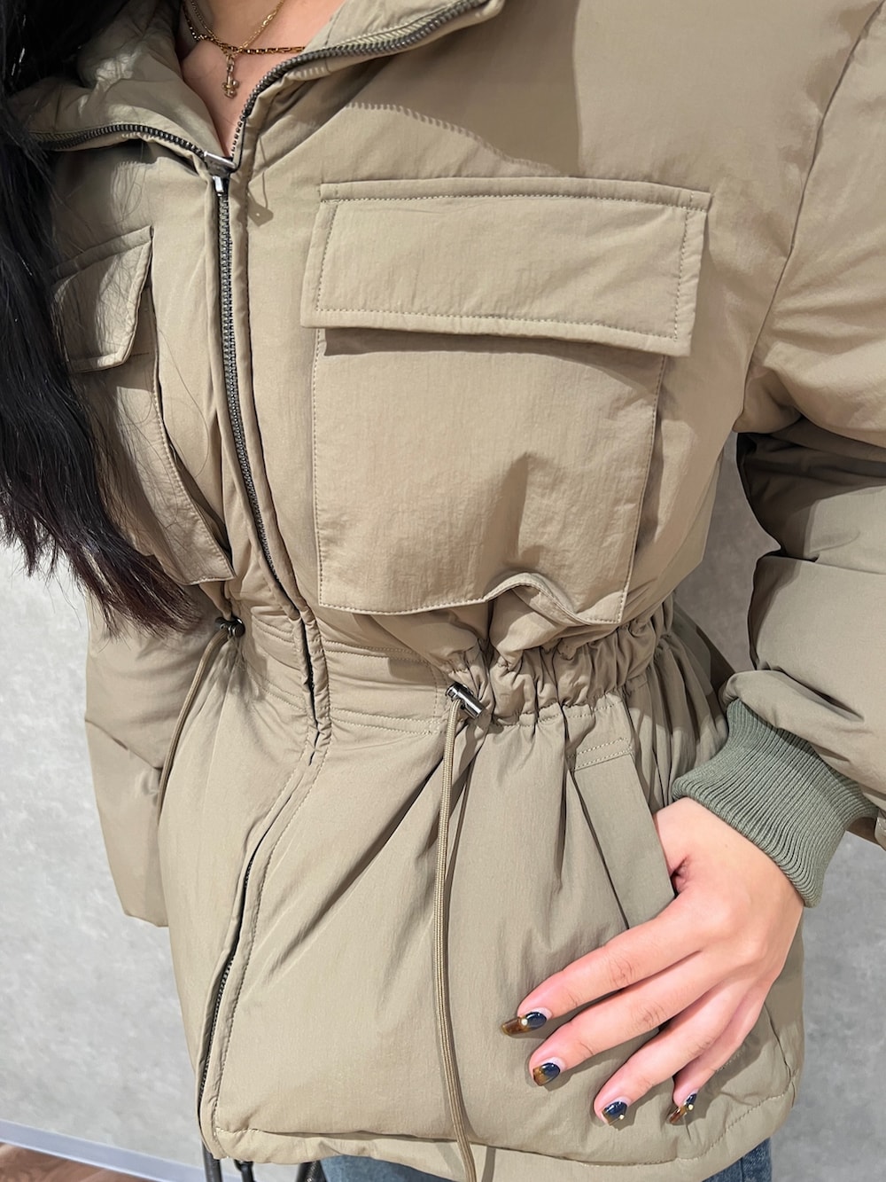 グリーン系のブルゾン、ブルー系のデニムパンツ、ブラック系のブーツを着用したレディースの秋コーディネートの4枚目の写真