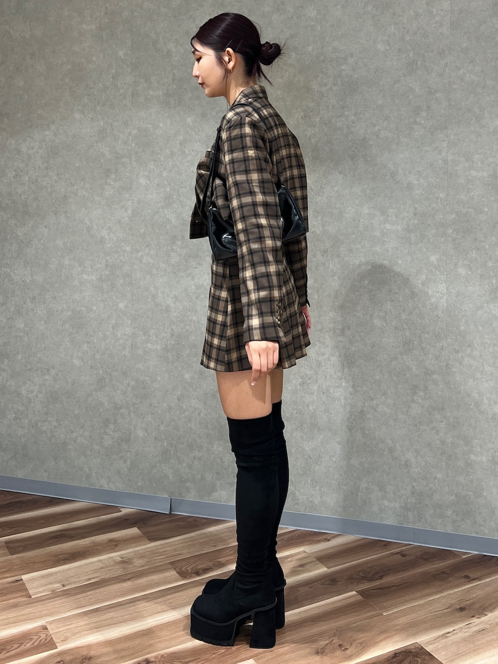 その他のテーラードジャケット、ブラック系のブーツ、ホワイト系のニット/セーターを着用したレディースの秋コーディネートの2枚目の写真