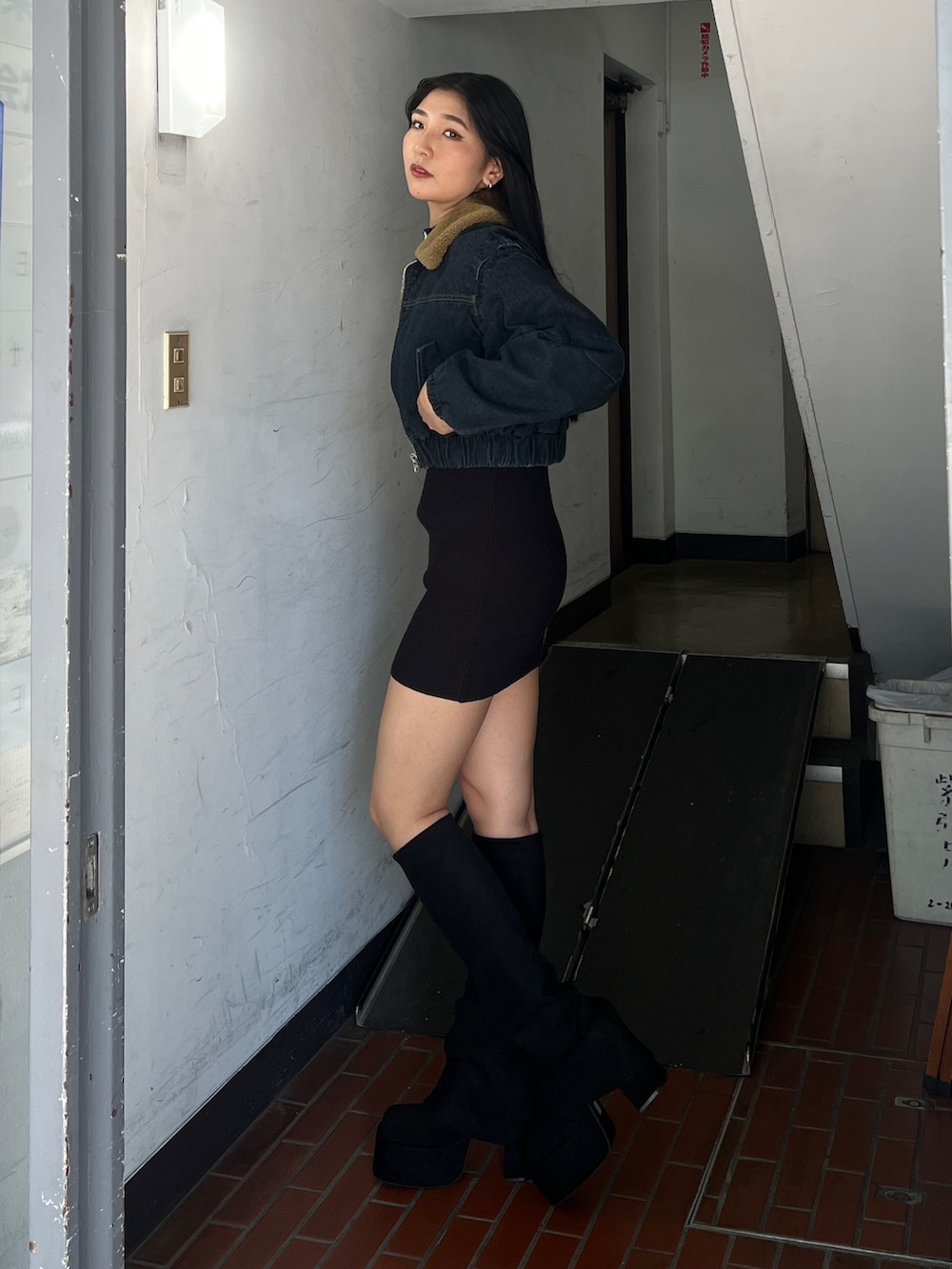 ブルー系のブルゾン、ブラウン系のワンピース、ブラック系のブーツを着用したレディースの夏コーディネートの2枚目の写真