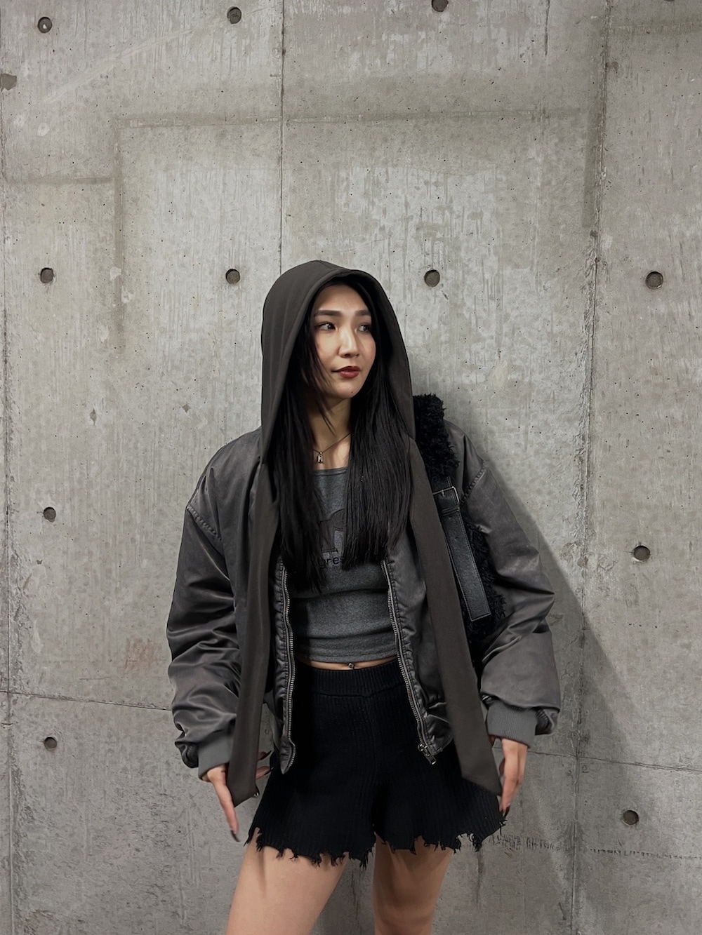 グレー系のブルゾン、グレー系のTシャツ/カットソー、ブラック系のブーツを着用したレディースの秋コーディネートの3枚目の写真