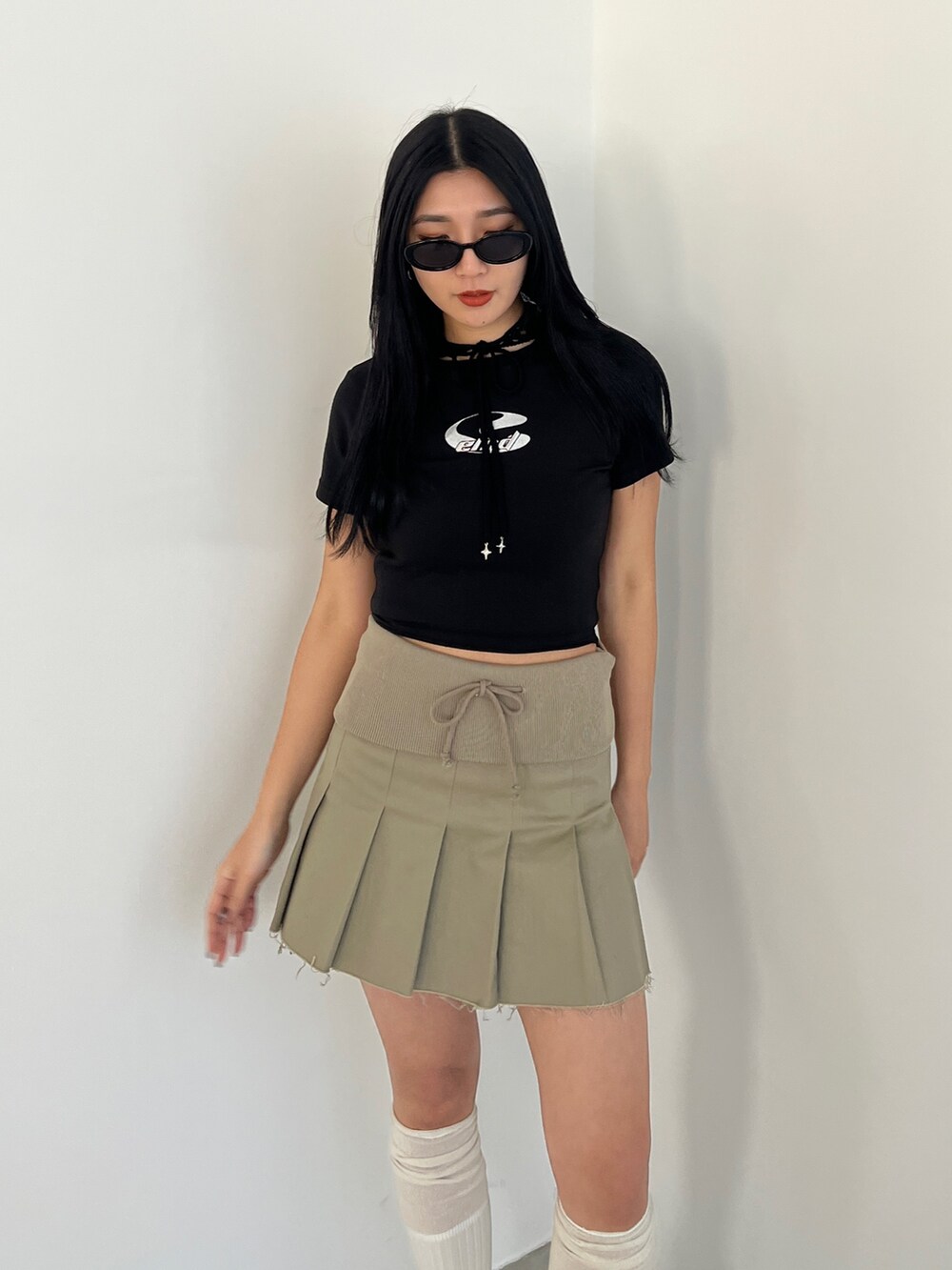 ベージュ系のスカート、ブラック系のローファー、ブラック系のTシャツ/カットソーを着用したレディースの春コーディネートの5枚目の写真