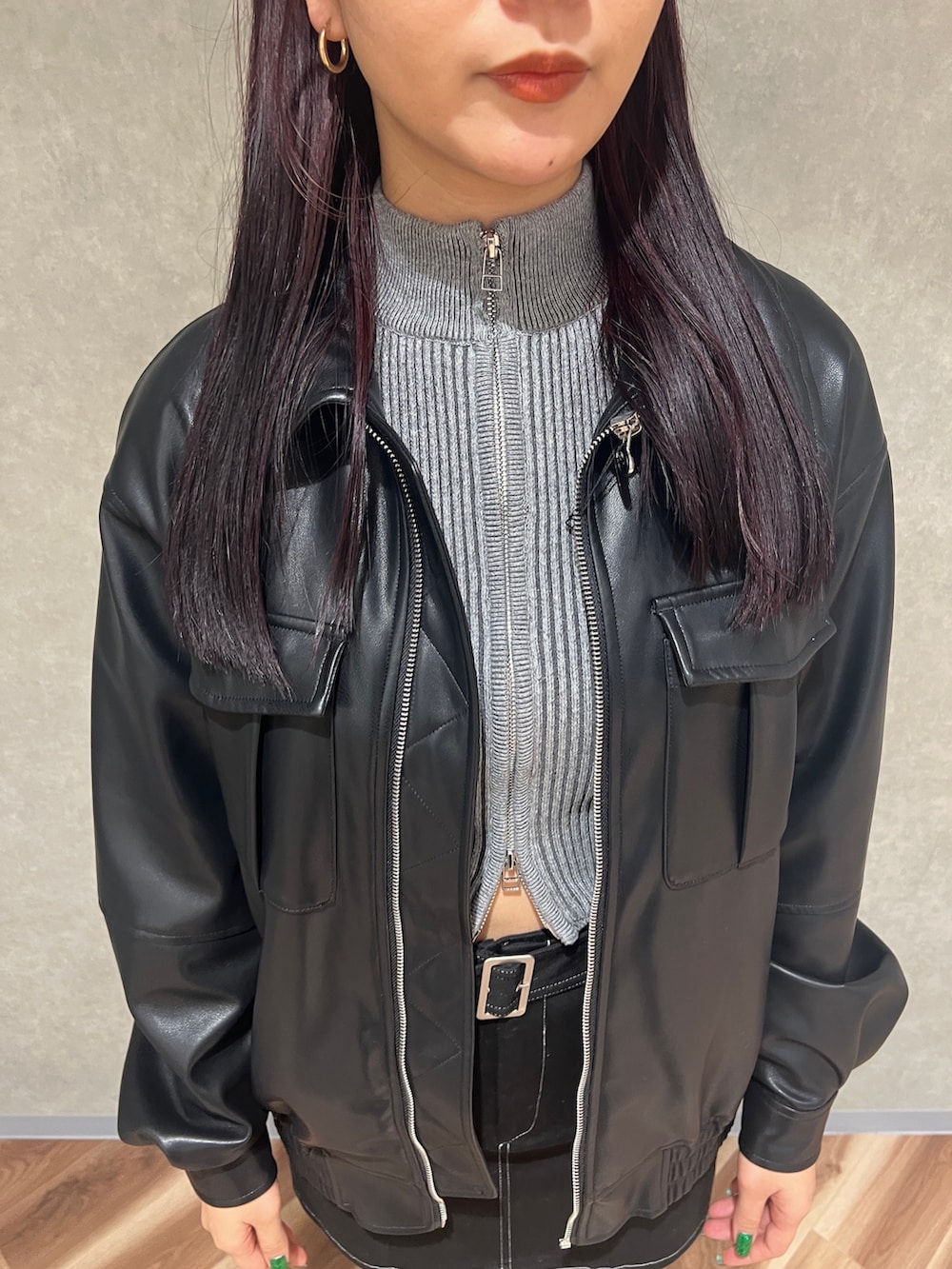 ブラック系のブルゾン、グレー系のニット/セーター、ブラック系のスカートを着用したレディースの冬コーディネートの4枚目の写真