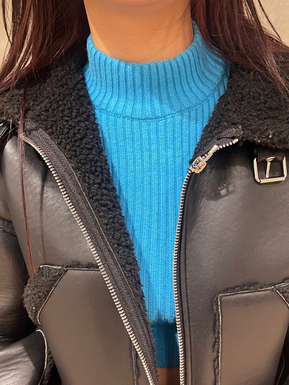 ブラック系のブルゾン、ブルー系のニット/セーター、ブラック系のデニムパンツを着用したレディースの冬コーディネートの5枚目の写真