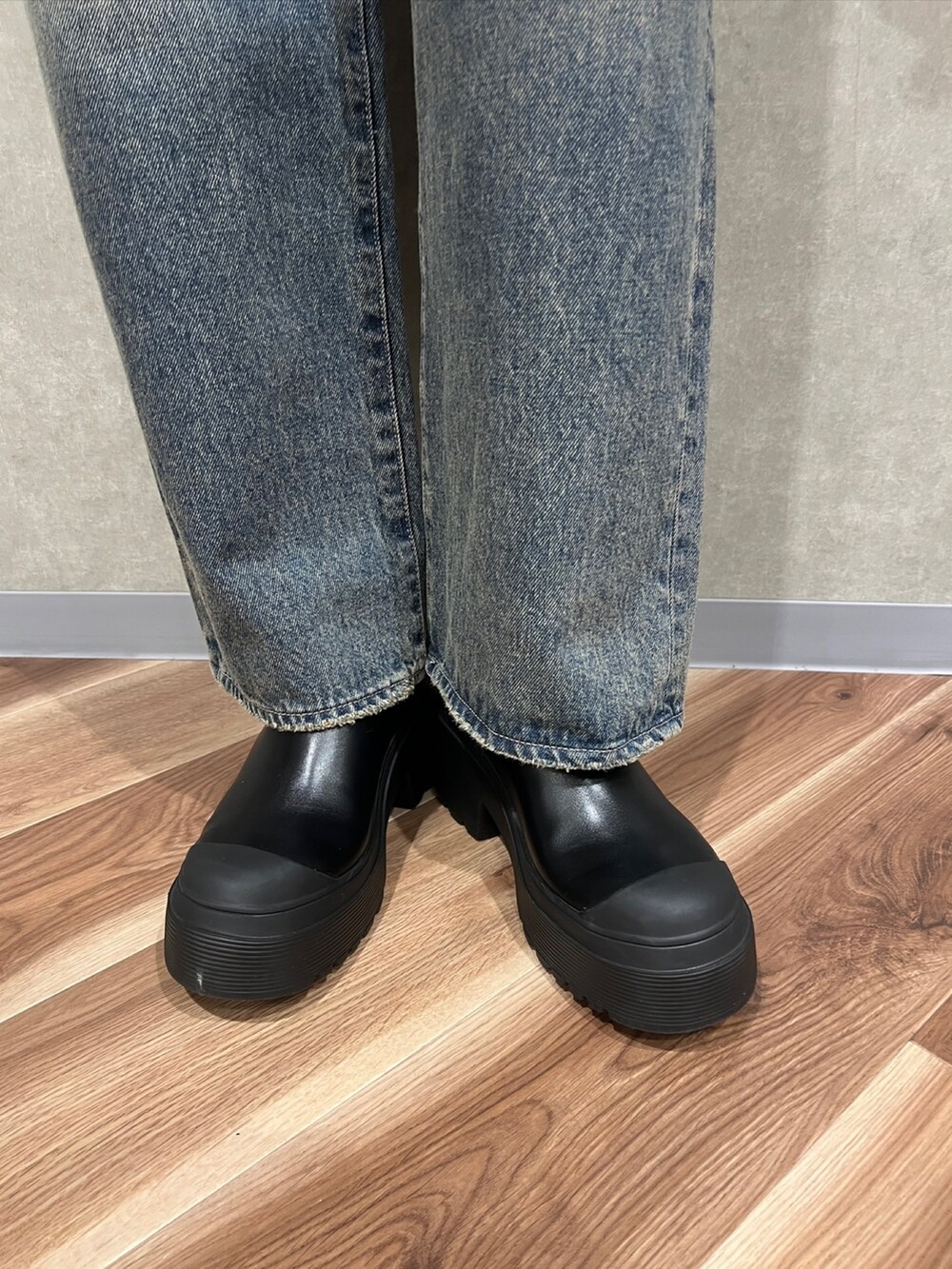 ブラック系のTシャツ/カットソー、ブルー系のデニムパンツ、ブラック系のブーツを着用したレディースの秋コーディネートの6枚目の写真