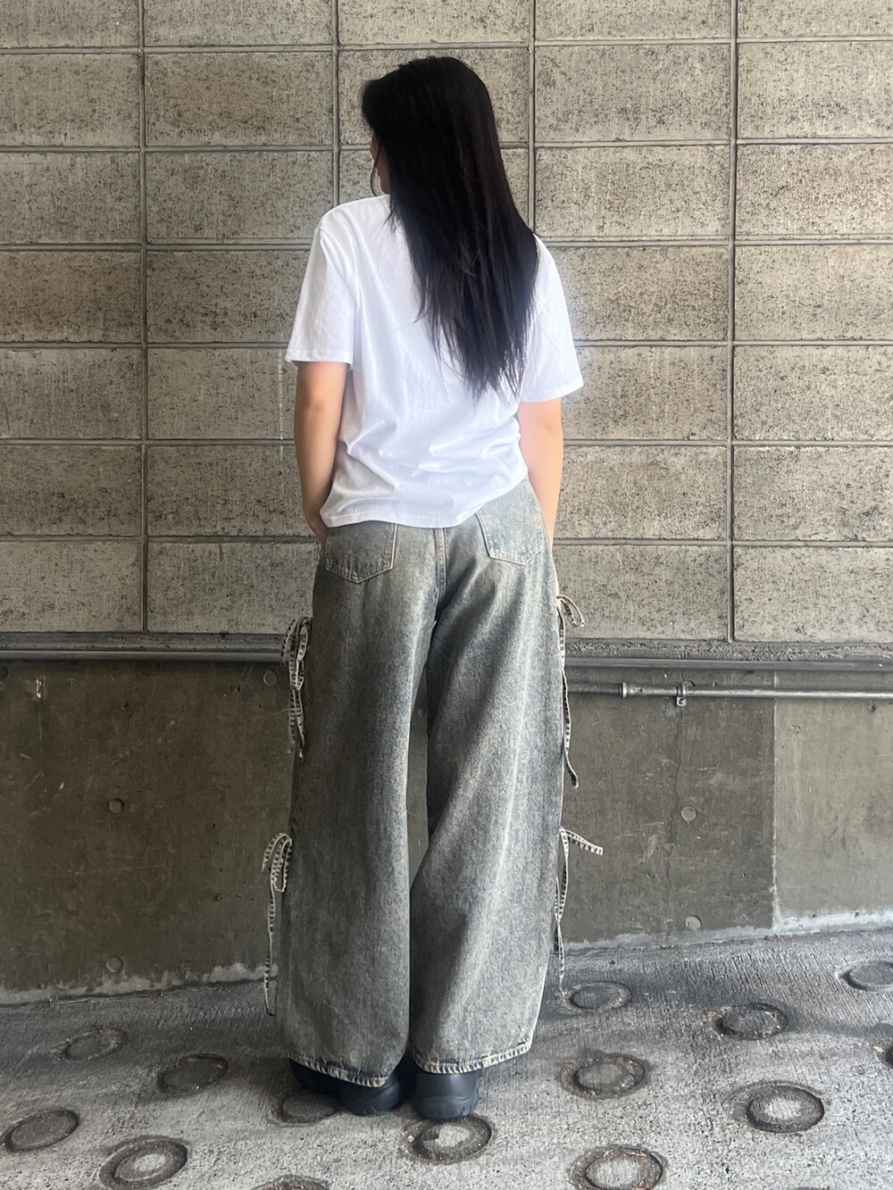 ホワイト系のTシャツ/カットソー、ブルー系のデニムパンツ、ブラック系のスニーカーを着用したレディースの春コーディネートの2枚目の写真