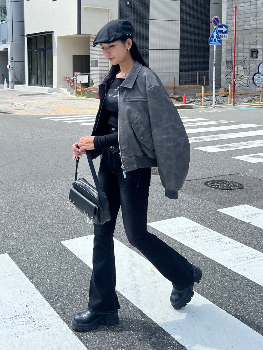 グレー系のブルゾン、ブラック系のデニムパンツ、ブラック系のブーツを着用したレディースの秋コーディネートの3枚目の写真