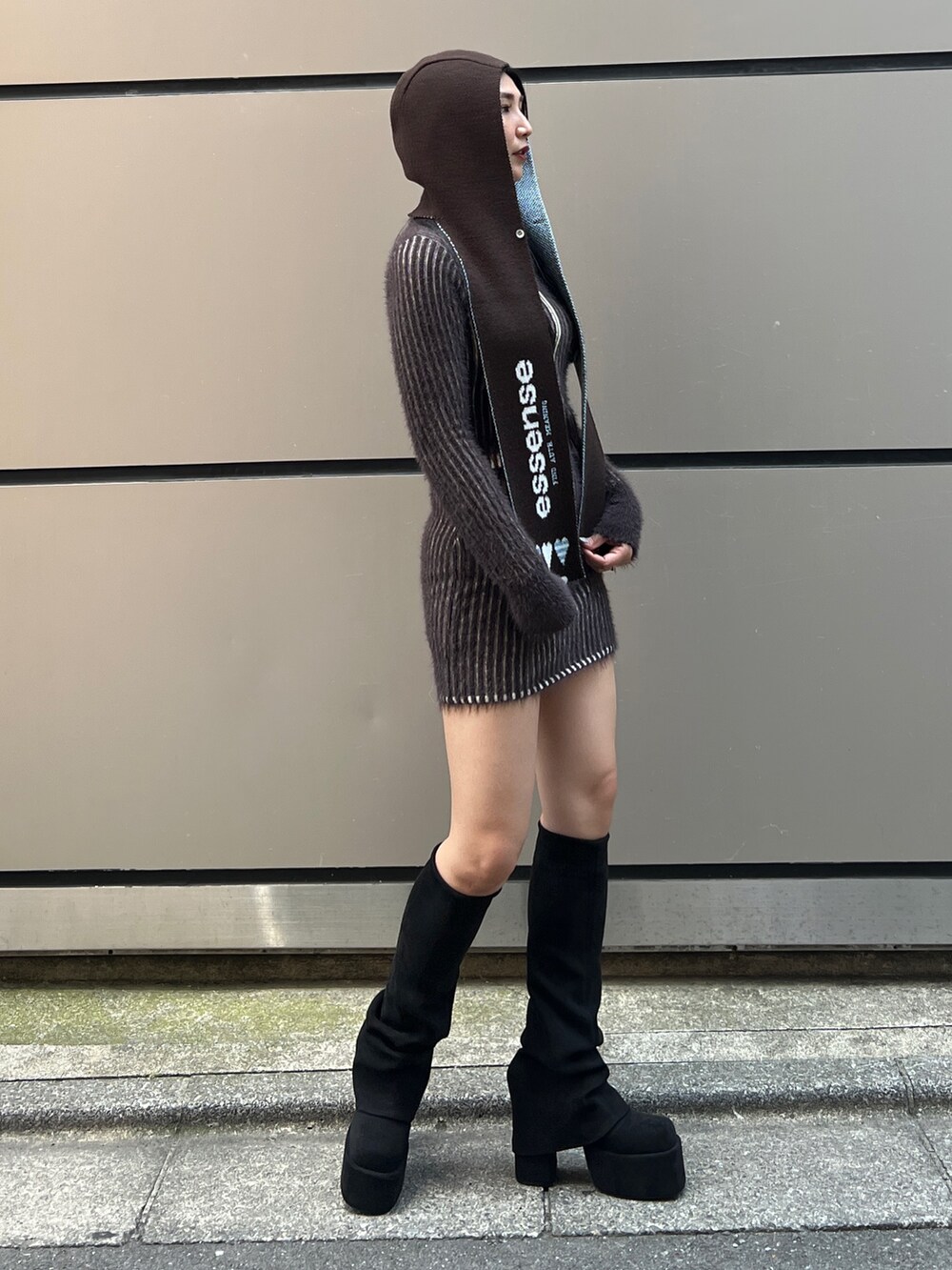 ブラック系のブーツ、ブラウン系のスカート、ブラウン系のニット/セーターを着用したレディースの夏コーディネートの2枚目の写真