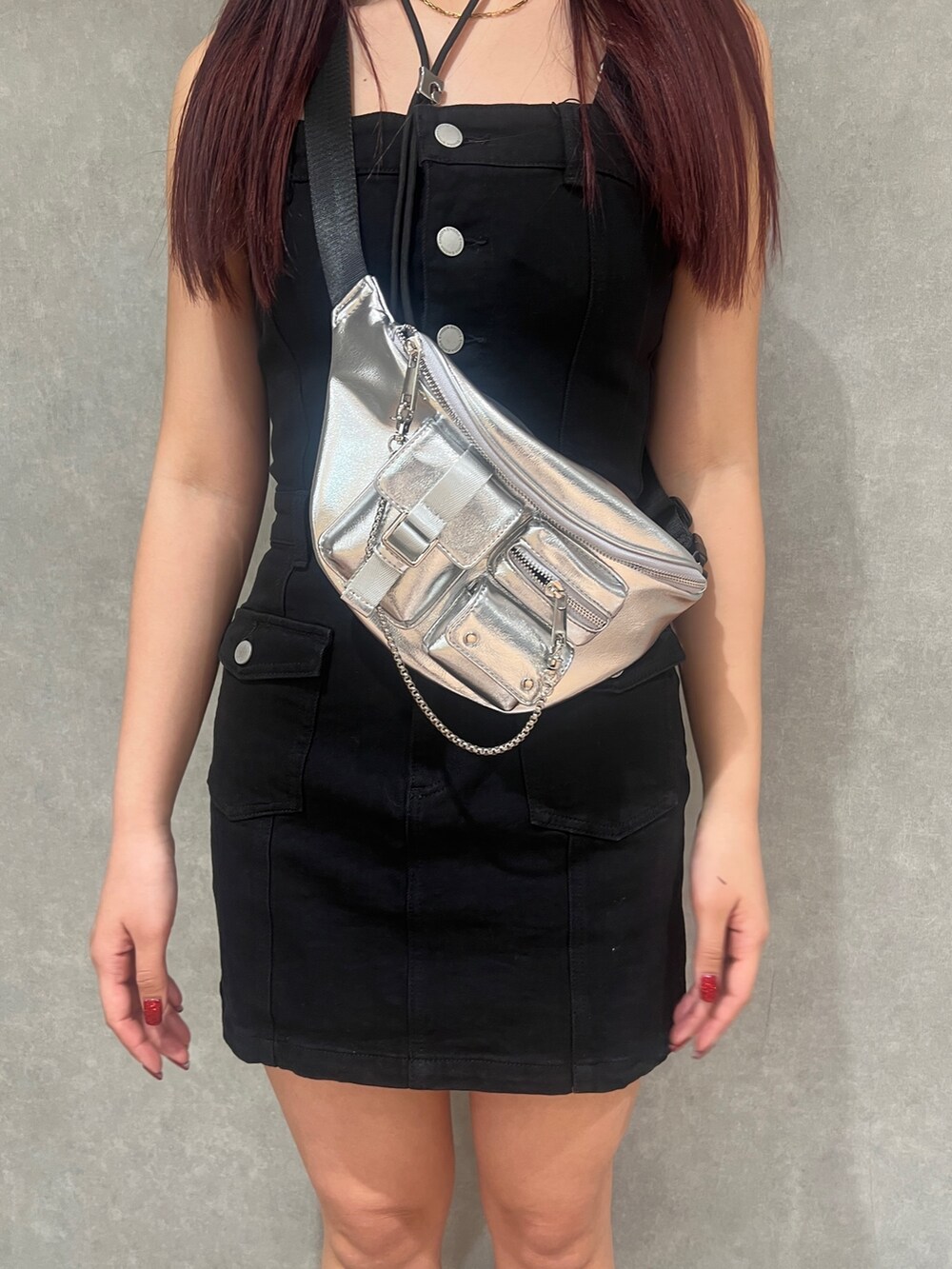 ブラック系のワンピース、ブラック系のブーツ、シルバー系のハンドバッグを着用したレディースの春コーディネートの4枚目の写真