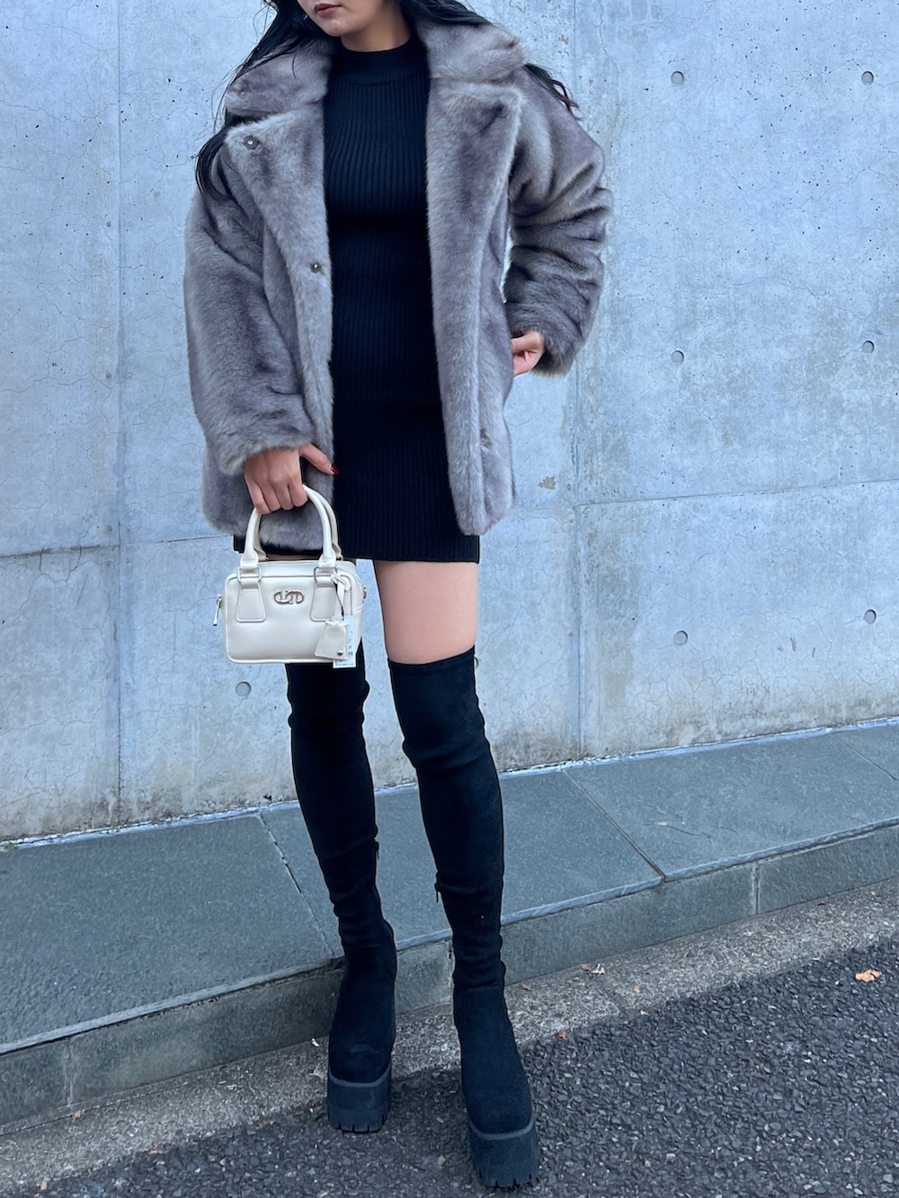 グレー系のその他アウター、ブラック系のワンピース、ブラック系のブーツを着用したレディースの冬コーディネートの4枚目の写真