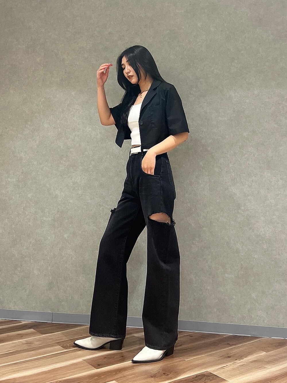 ブルー系のデニムパンツ、ホワイト系のニット/セーター、ホワイト系のブーツを着用したレディースの夏コーディネートの2枚目の写真