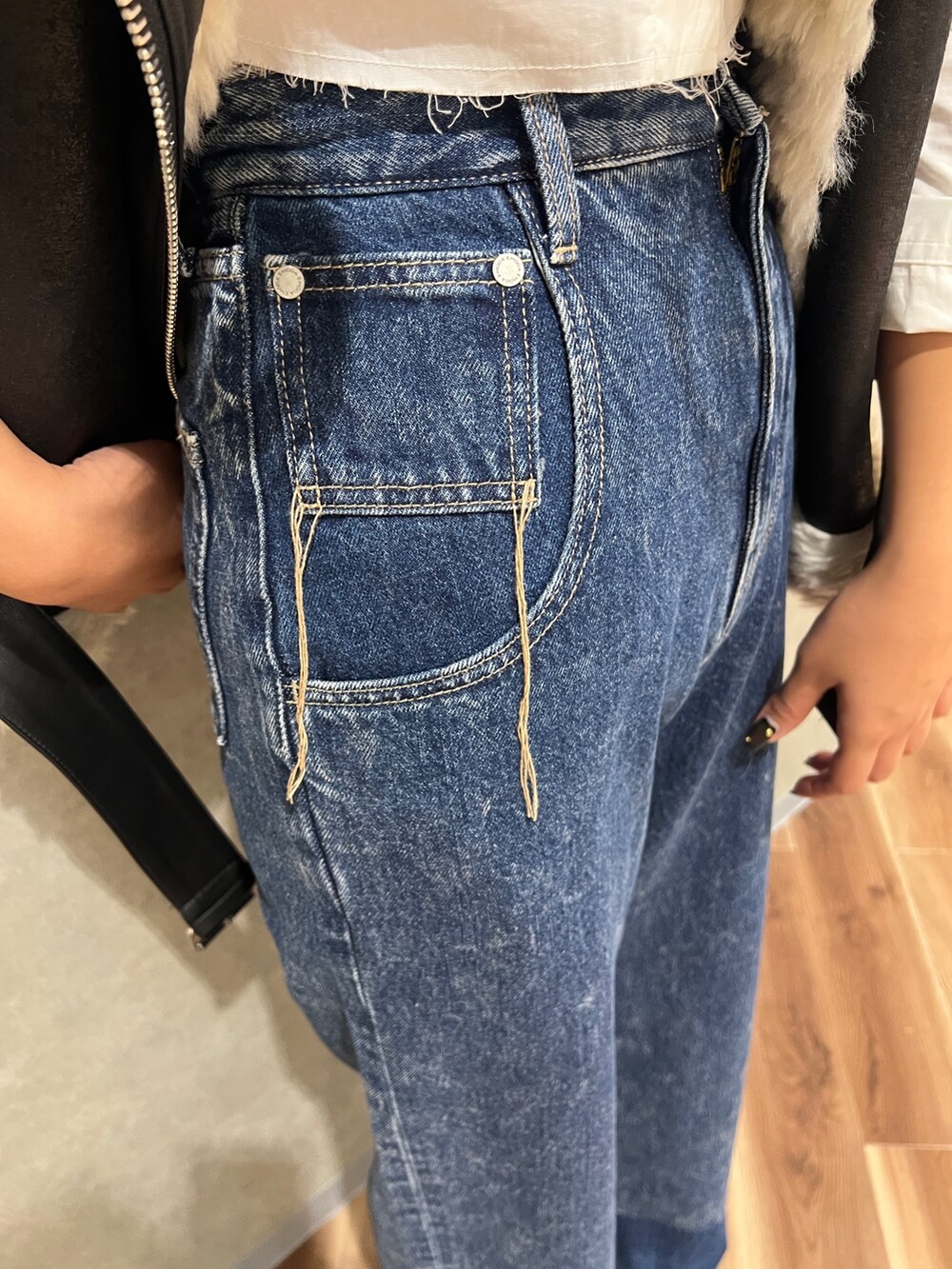 ブラック系のムートンコート、ホワイト系のシャツ/ブラウス、ブルー系のデニムパンツを着用したレディースの秋コーディネートの6枚目の写真