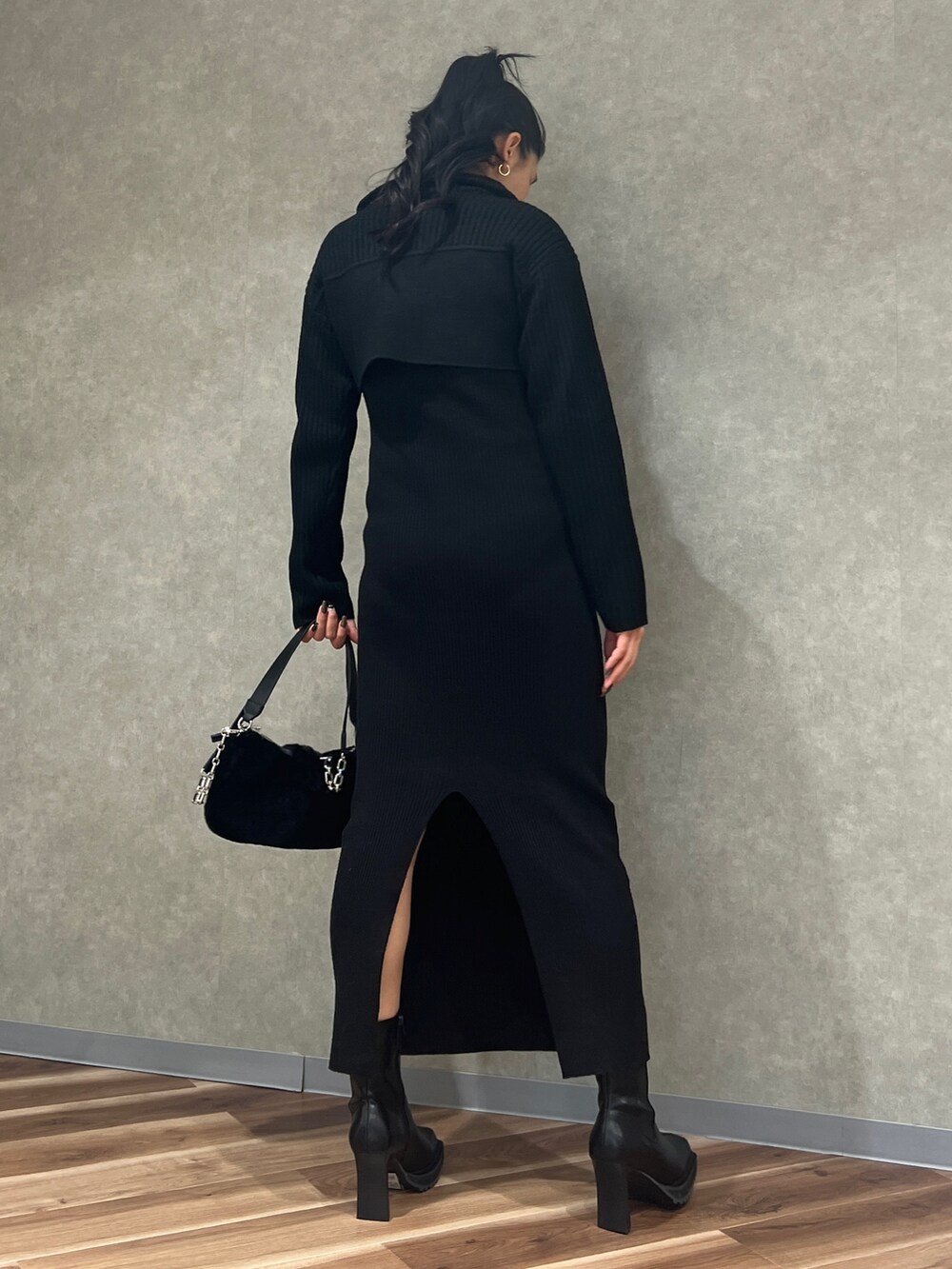 ブラック系のワンピース、ブラック系のハンドバッグ、ブラック系のブーツを着用したレディースの秋コーディネートの3枚目の写真