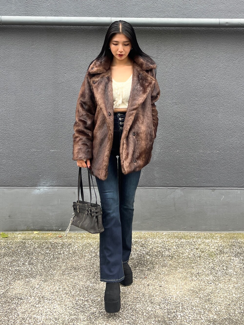 ブラウン系のその他アウター、ホワイト系のニット/セーター、ブルー系のデニムパンツを着用したレディースの秋コーディネートの3枚目の写真