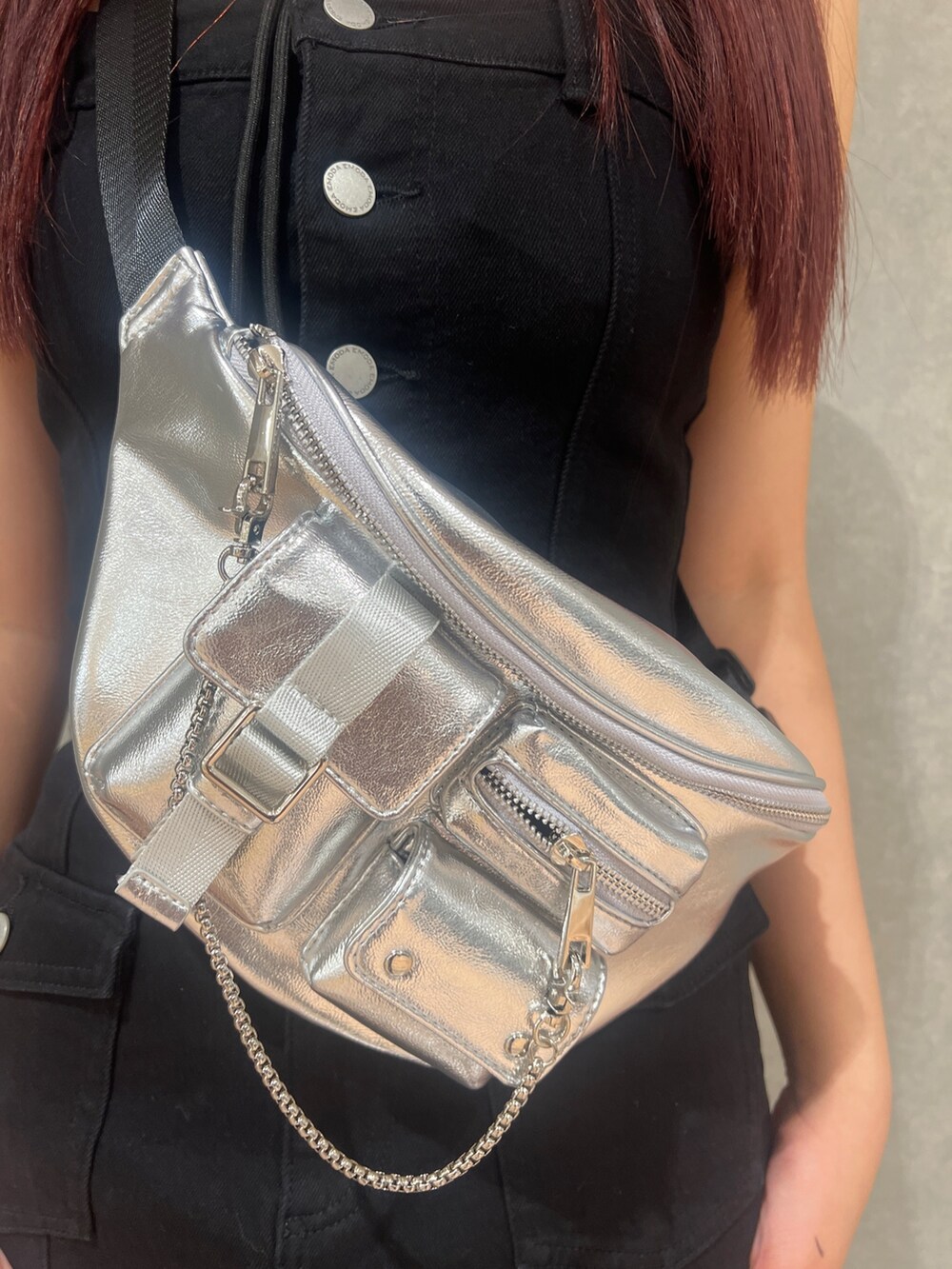 ブラック系のワンピース、ブラック系のブーツ、シルバー系のハンドバッグを着用したレディースの春コーディネートの5枚目の写真