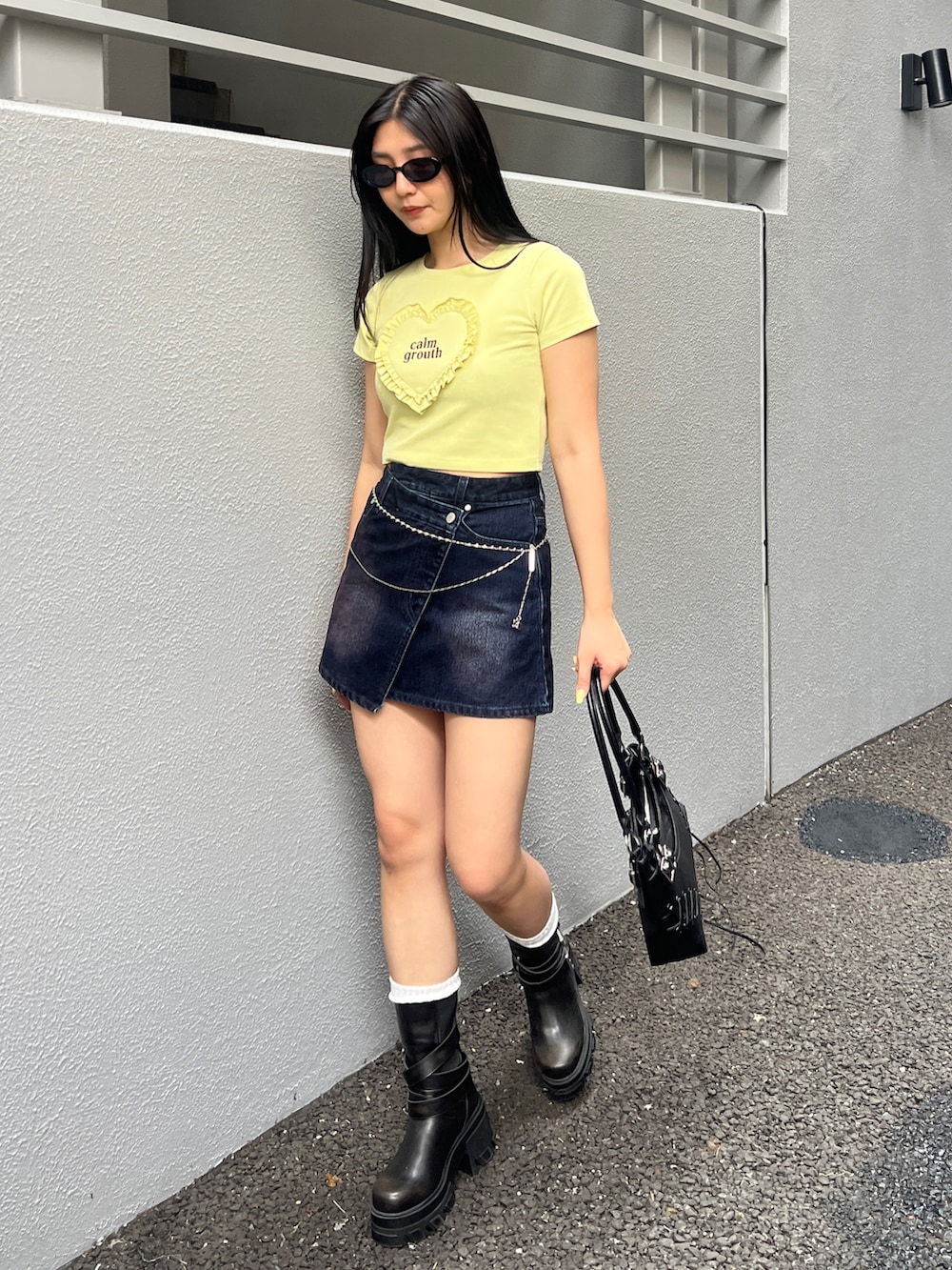 イエロー系のTシャツ/カットソー、ブルー系のスカート、ブラック系のブーツを着用したレディースの夏コーディネートの2枚目の写真