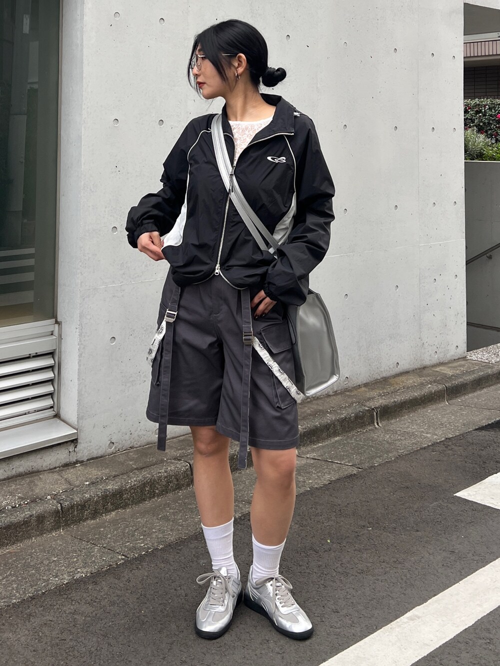 ブラック系のブルゾン、ホワイト系のTシャツ/カットソー、シルバー系のスニーカーを着用したレディースの春コーディネートの3枚目の写真