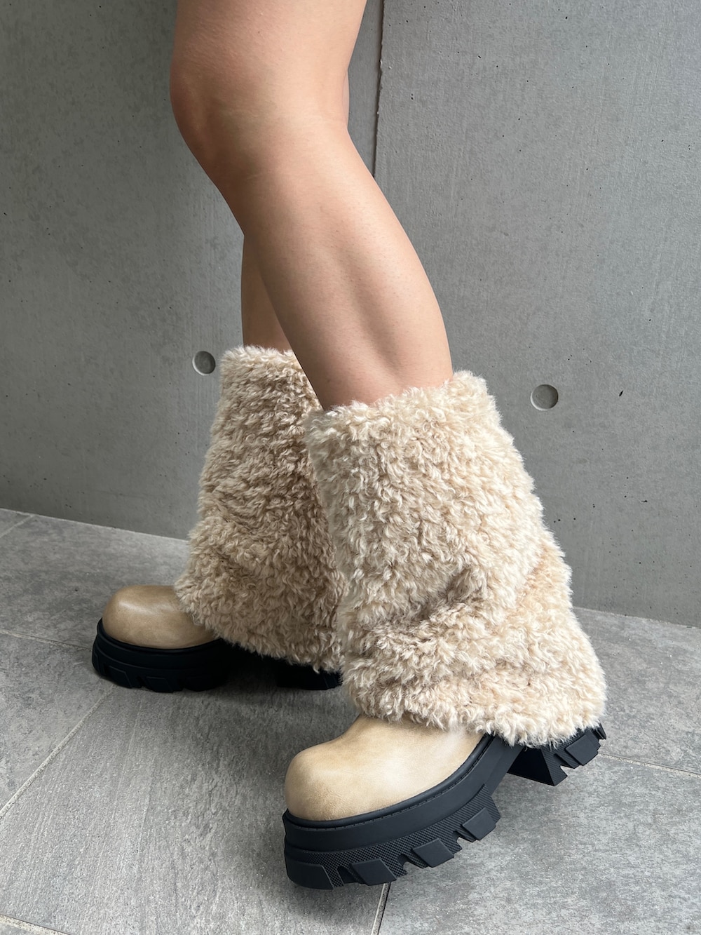 ブラック系のパーカー、ベージュ系のスカート、ホワイト系のブーツを着用したレディースの冬コーディネートの4枚目の写真