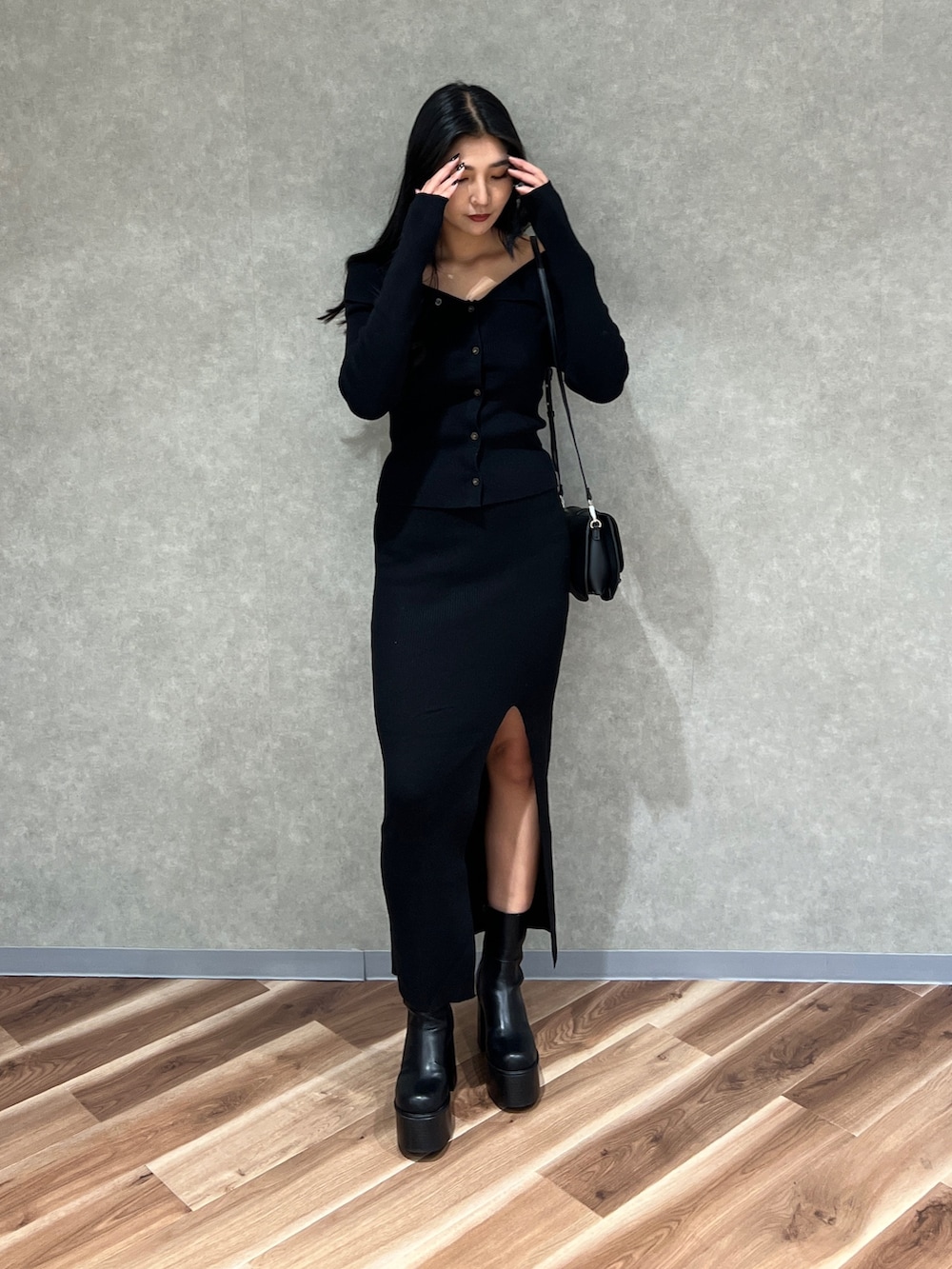 ブラック系のニット/セーター、ブラック系のスカート、ブラック系のブーツを着用したレディースの秋コーディネートの4枚目の写真