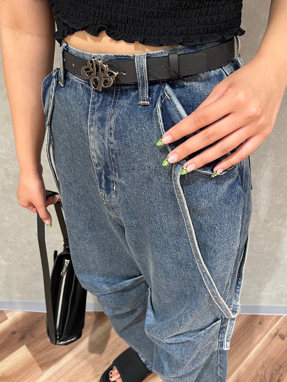 ブルー系のデニムパンツ、ブラック系のサンダル、ホワイト系のTシャツ/カットソーを着用したレディースの夏コーディネートの6枚目の写真