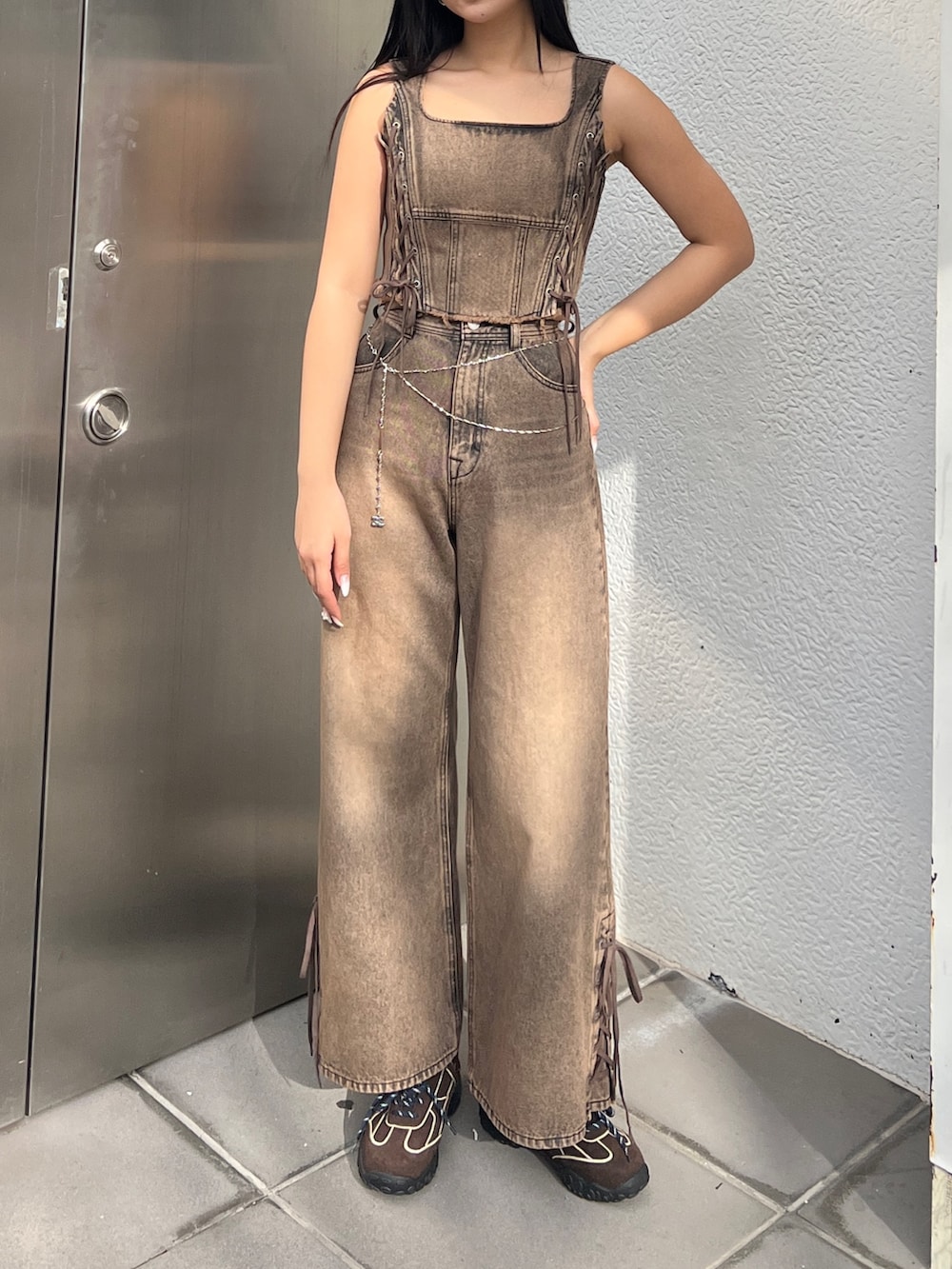 ブラウン系のタンクトップ、ブラウン系のデニムパンツ、ブラウン系のスニーカーを着用したレディースの春コーディネートの2枚目の写真