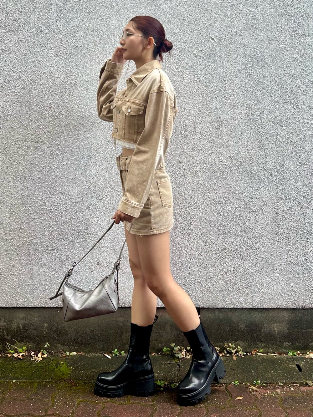 ベージュ系のデニムジャケット、ベージュ系のデニムスカート、シルバー系のハンドバッグを着用したレディースの夏コーディネートの2枚目の写真