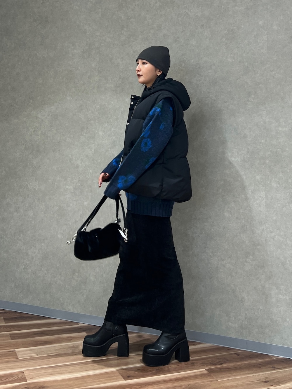 ブルー系のニット/セーター、ブラック系のブルゾン、ブラック系のスカートを着用したレディースの秋コーディネートの3枚目の写真