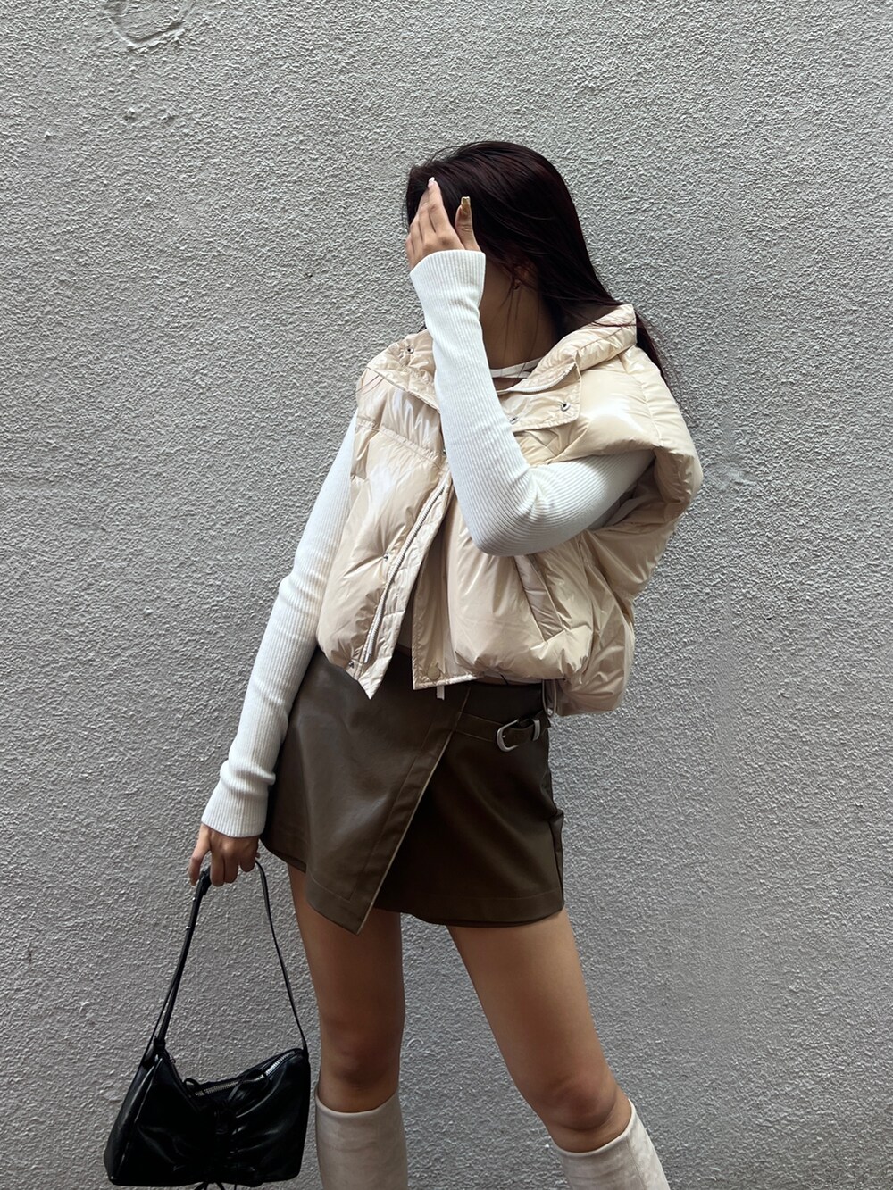 ホワイト系のダウンベスト、ホワイト系のニット/セーター、ブラウン系のその他パンツを着用したレディースの秋コーディネートの4枚目の写真