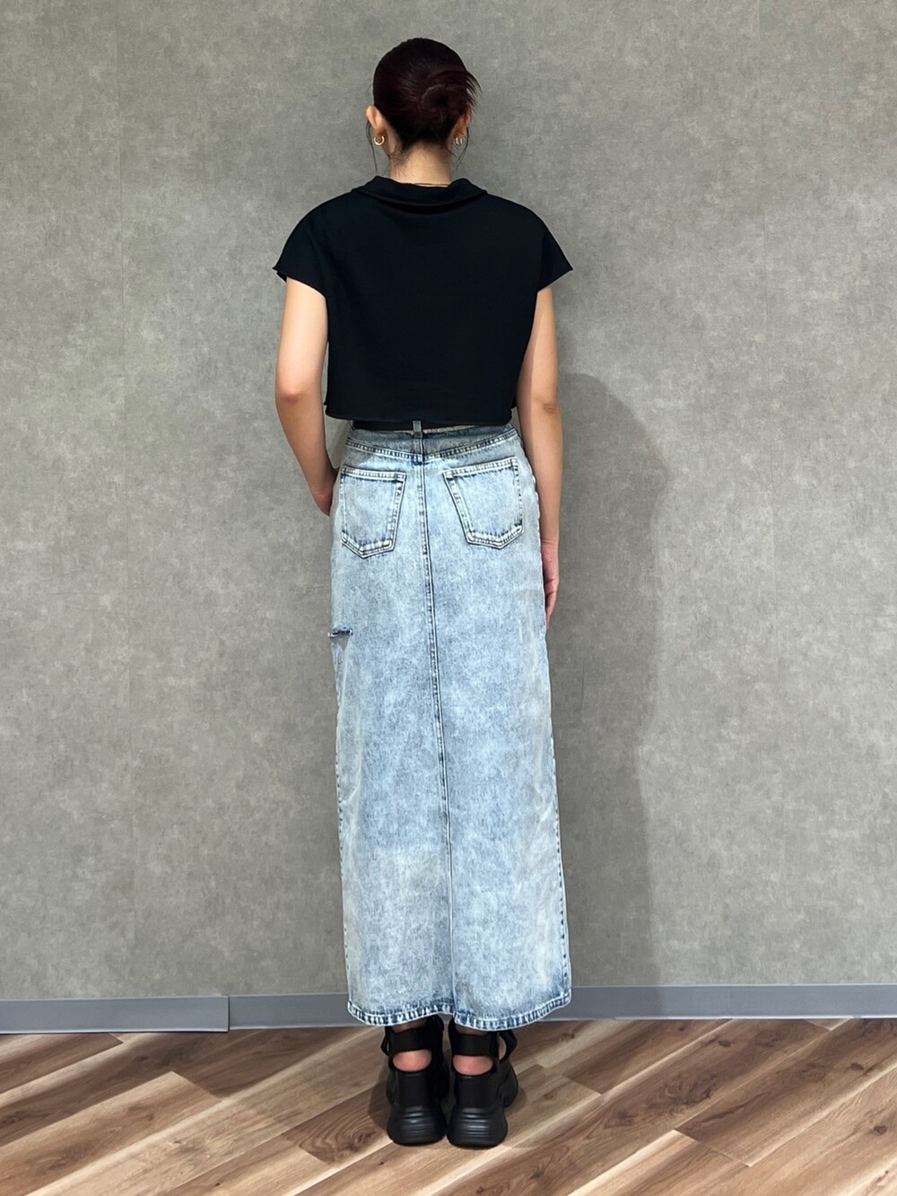 ブラック系のTシャツ/カットソー、ブルー系のデニムスカート、ブラック系のサンダルを着用したレディースの夏コーディネートの4枚目の写真