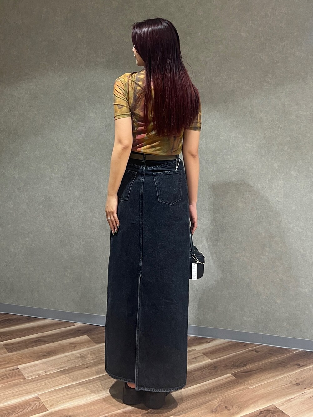 ブラック系のキャミソール、オレンジ系のTシャツ/カットソー、ブラック系のスカートを着用したレディースの夏コーディネートの4枚目の写真